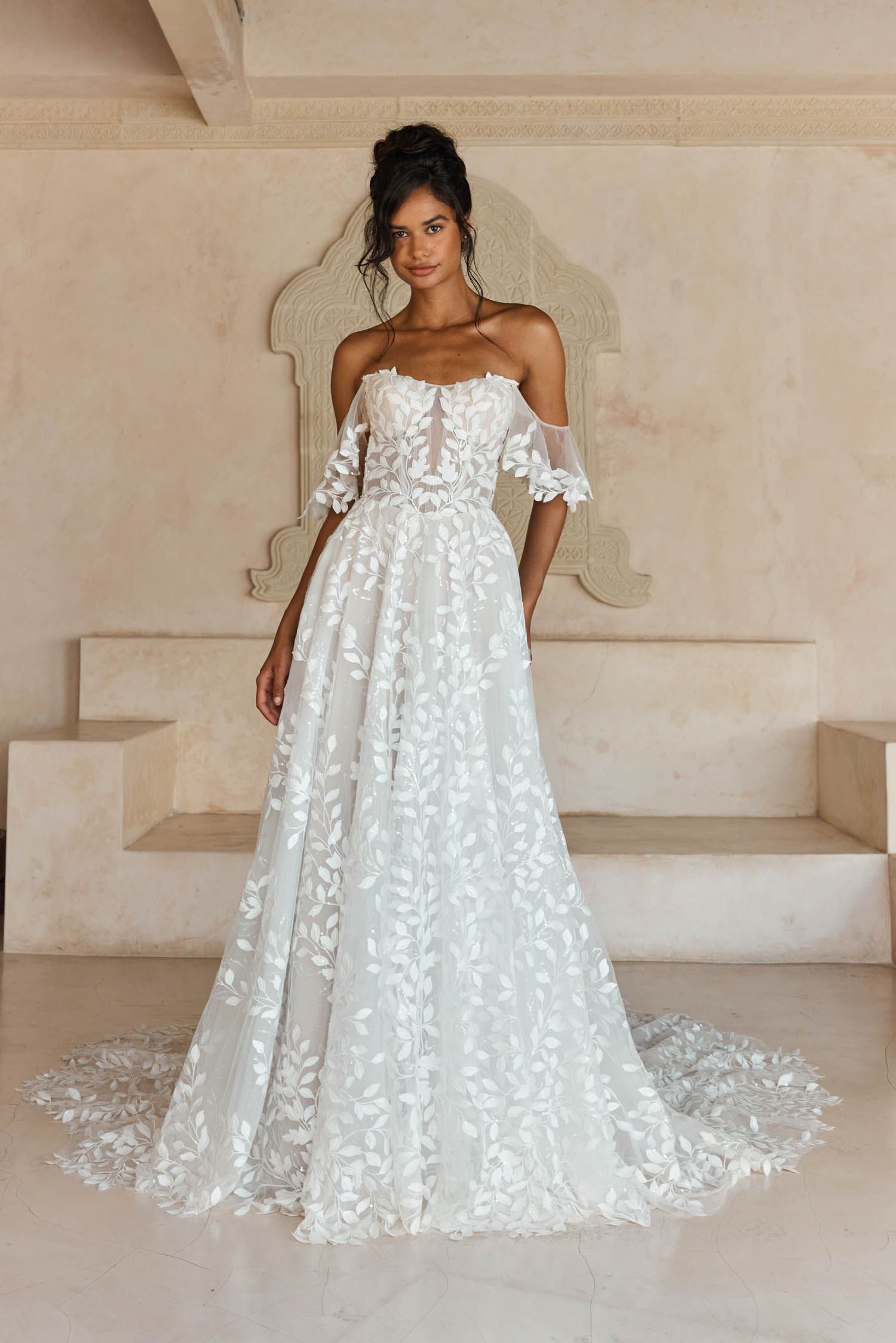 Eine Frau in einem Brautkleid steht in der Wüste.