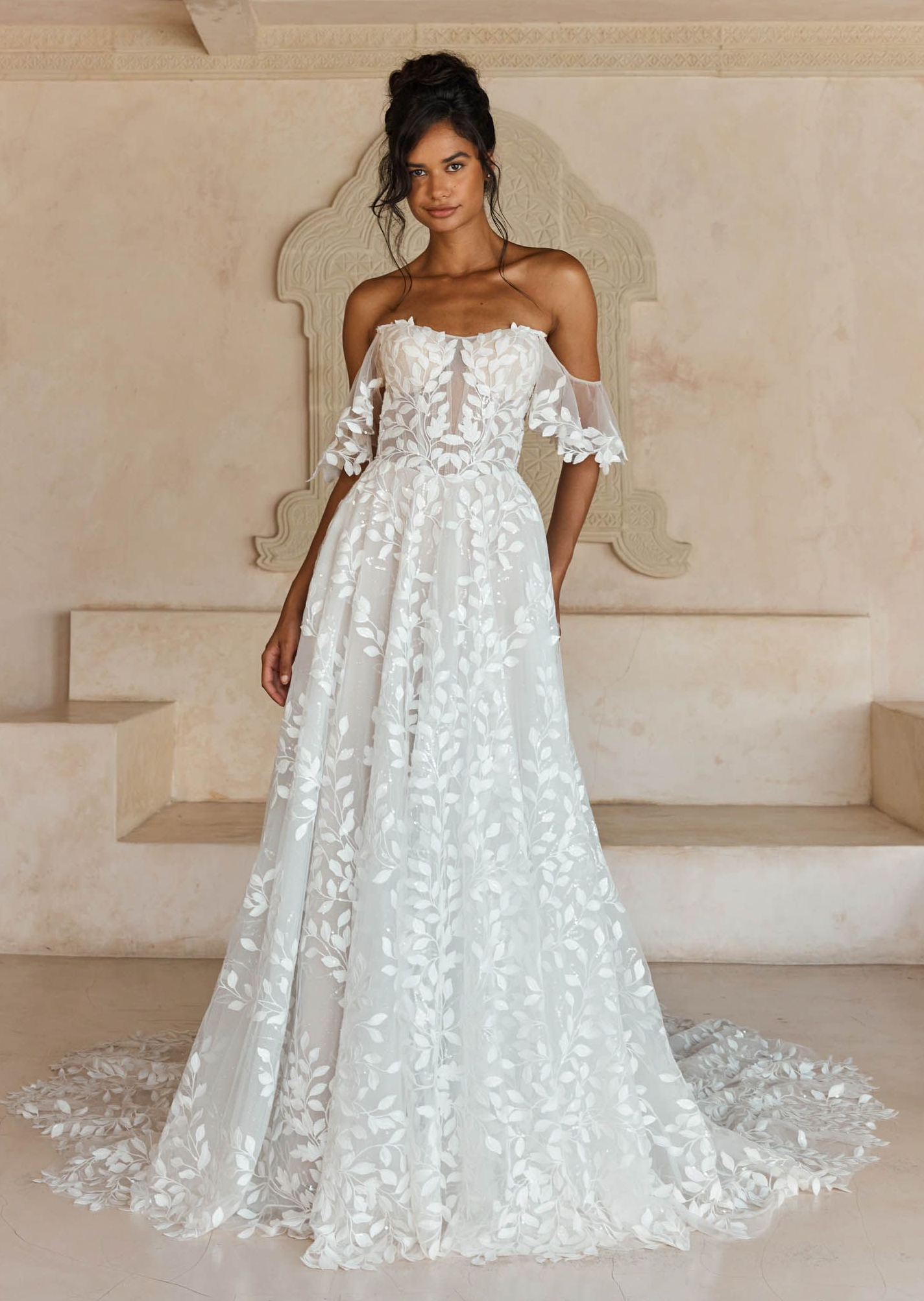 Eine Frau in einem Brautkleid steht in der Wüste.
