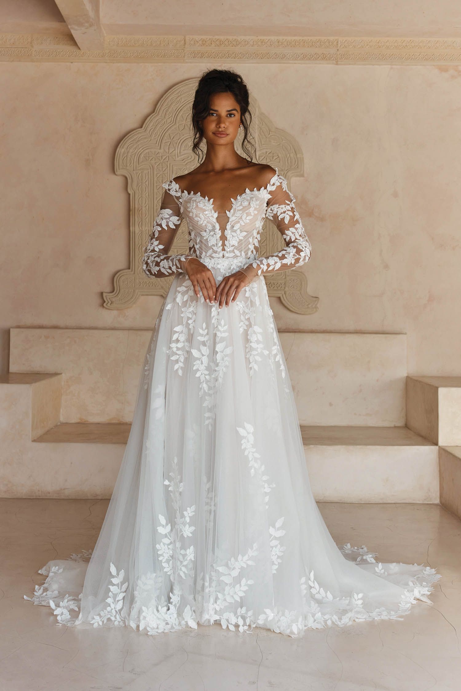 Eine Frau in einem Brautkleid steht in der Wüste.