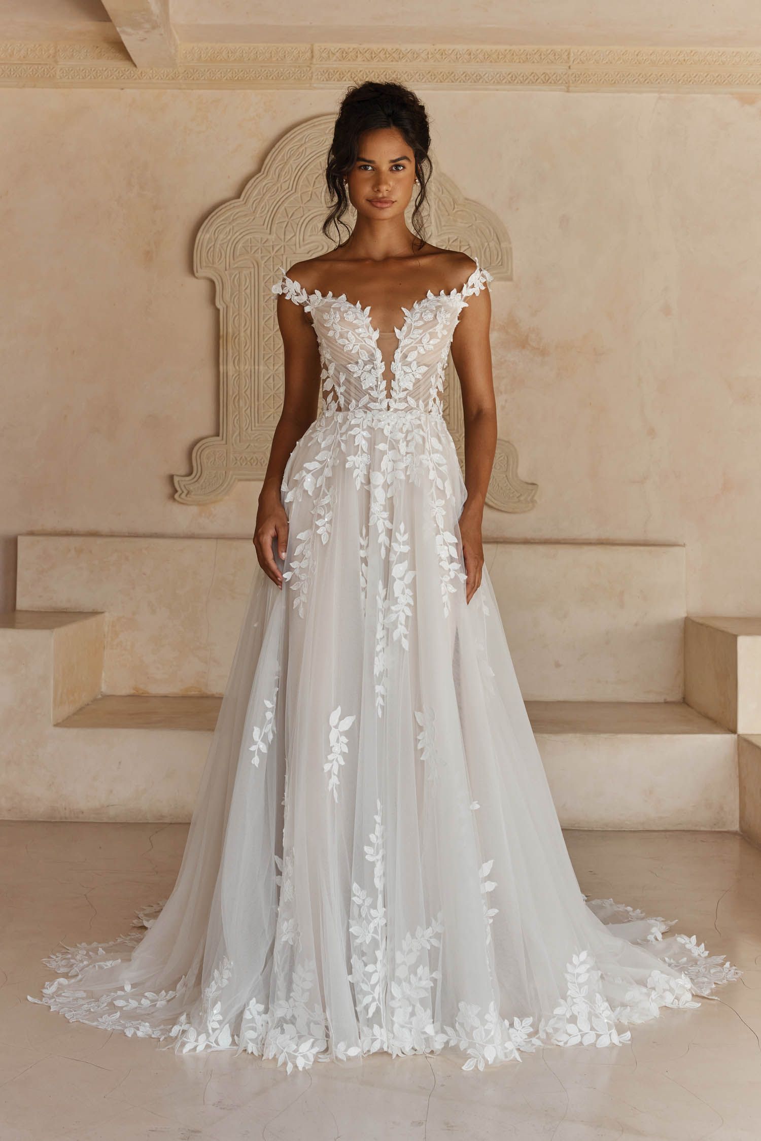 Eine Frau in einem Brautkleid steht in der Wüste.