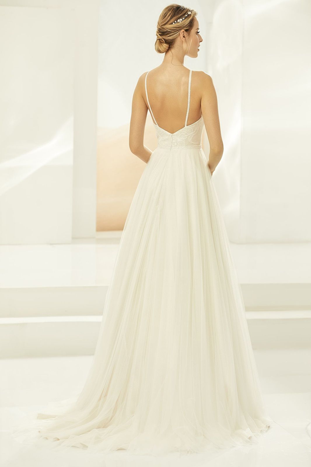 Eine Frau in einem Brautkleid steht auf einer Treppe vor einem Gebäude.