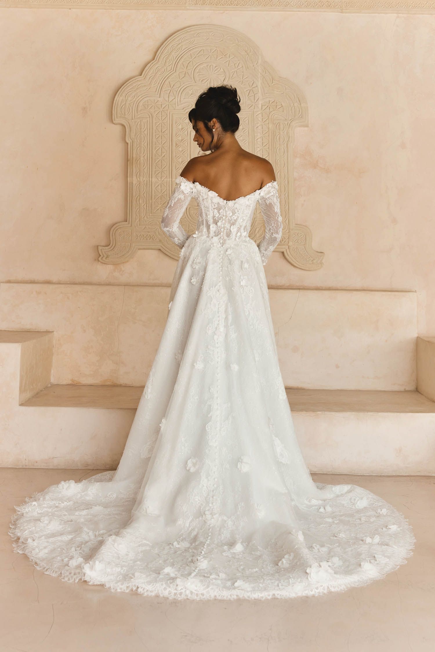 Eine Frau in einem Brautkleid steht in der Wüste.