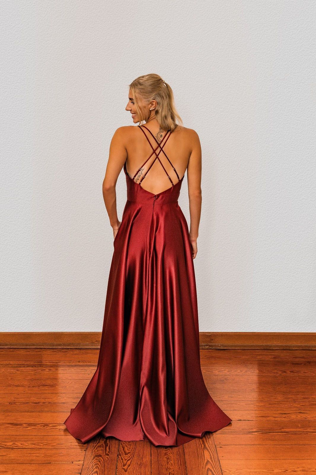 Zu sehen ist der Rücken einer Frau in einem roten Kleid.