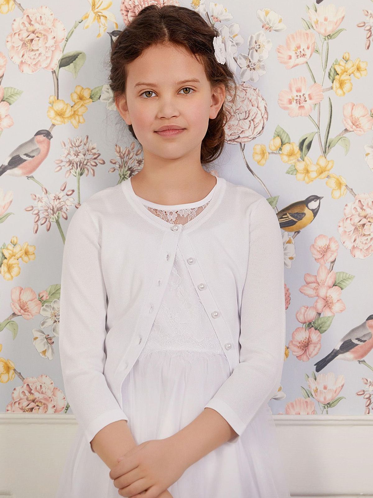 Mädchen in weißem Kommunionskleid mit weißem Bolero