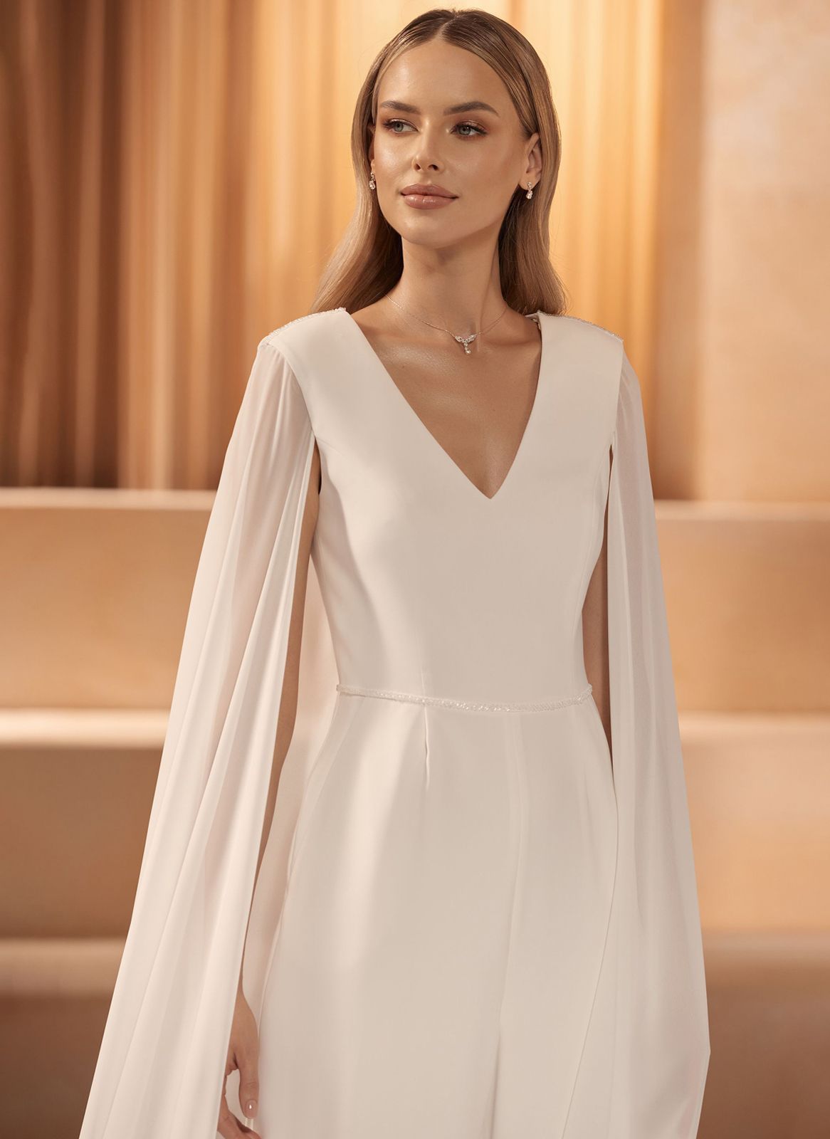 Eine Frau trägt ein schulterfreies weißes Brautkleid.