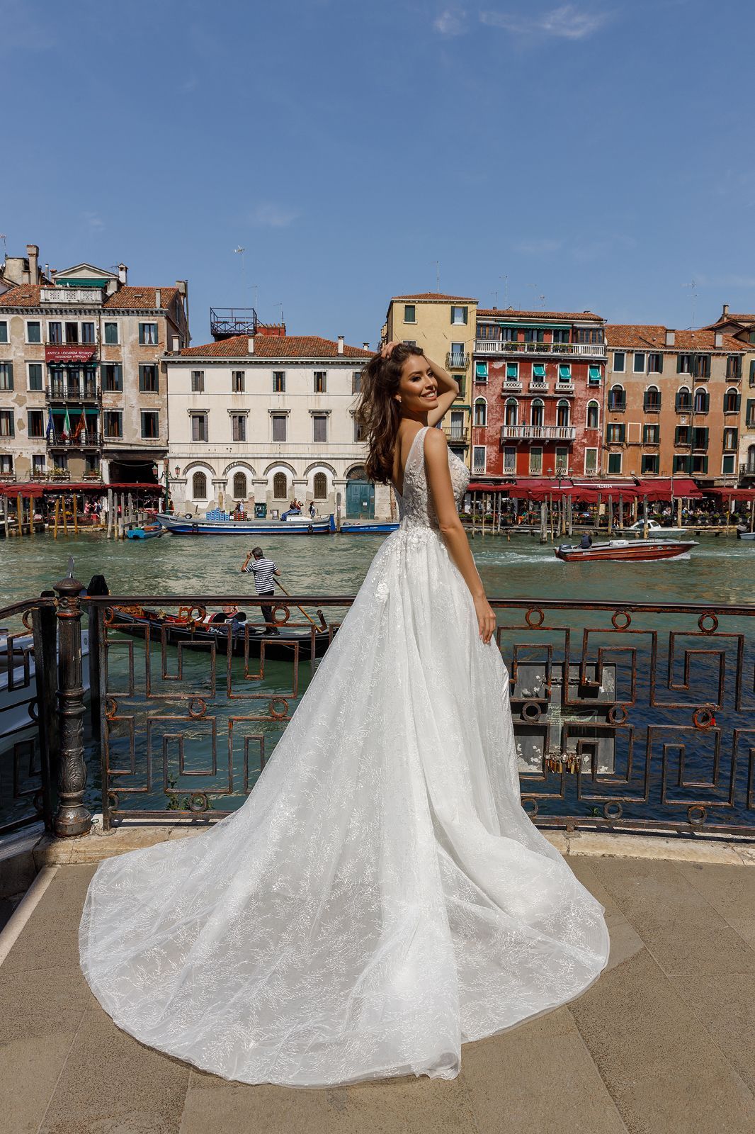 Eine Frau trägt ein weißes Brautkleid mit langen Ärmeln und einer Schleppe.