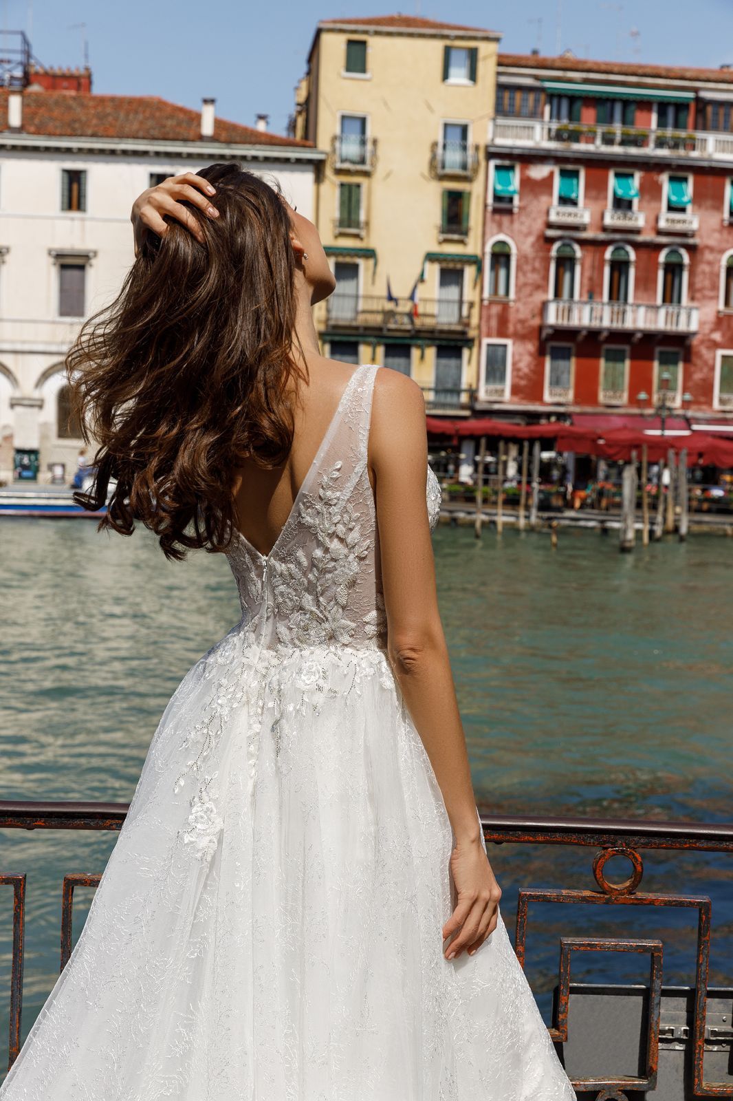 Eine Frau trägt ein weißes Kleid mit einer Schulter und langen Ärmeln.