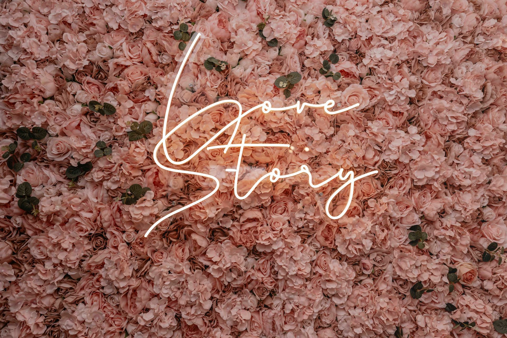 Ein Haufen rosa Blumen mit den Worten „Liebesgeschichte“ darauf.