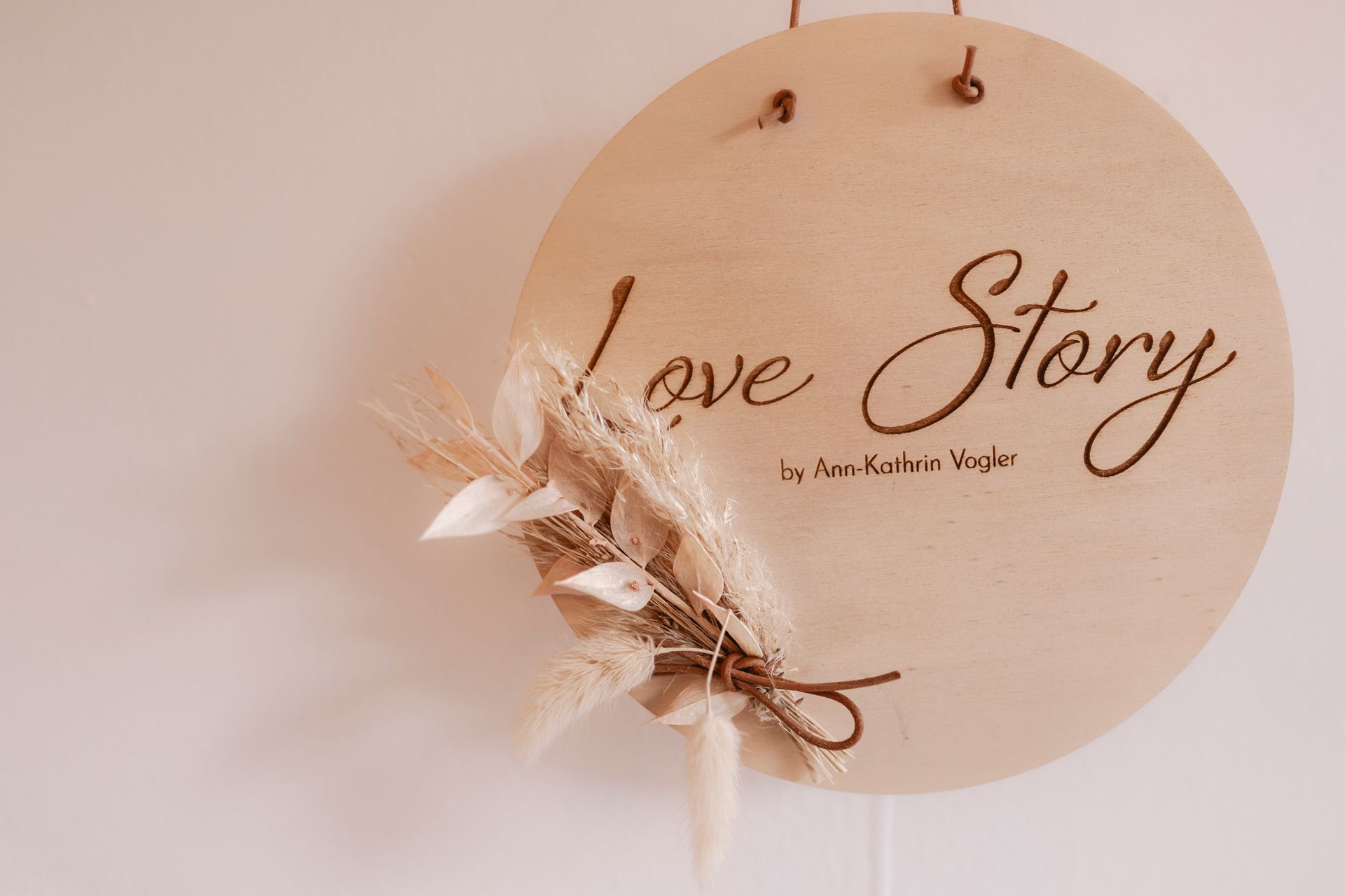 An einer Wand hängt ein Holzschild mit der Aufschrift „Liebesgeschichte“.