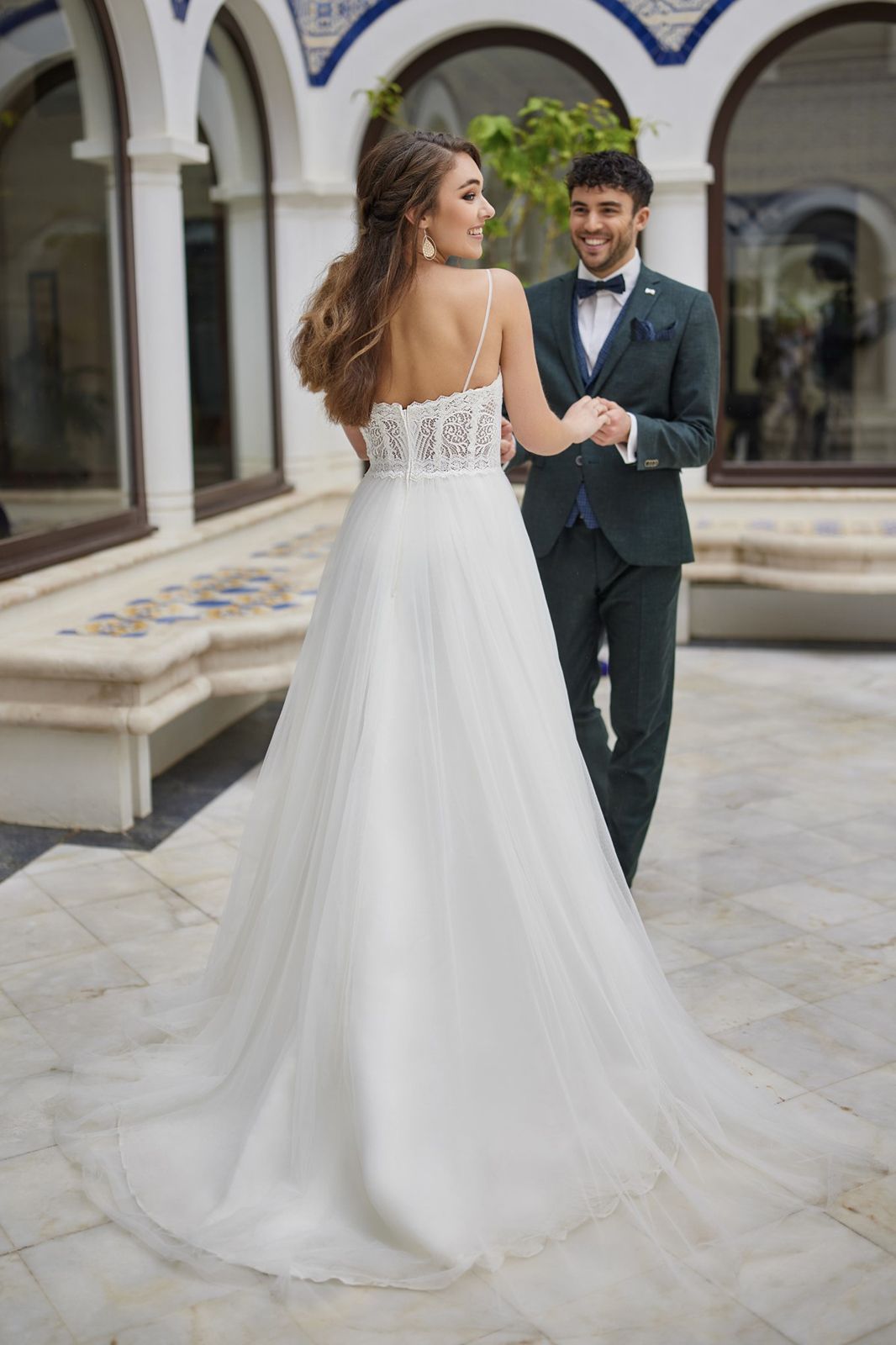 Eine Frau in einem Brautkleid steht vor einem Gebäude.