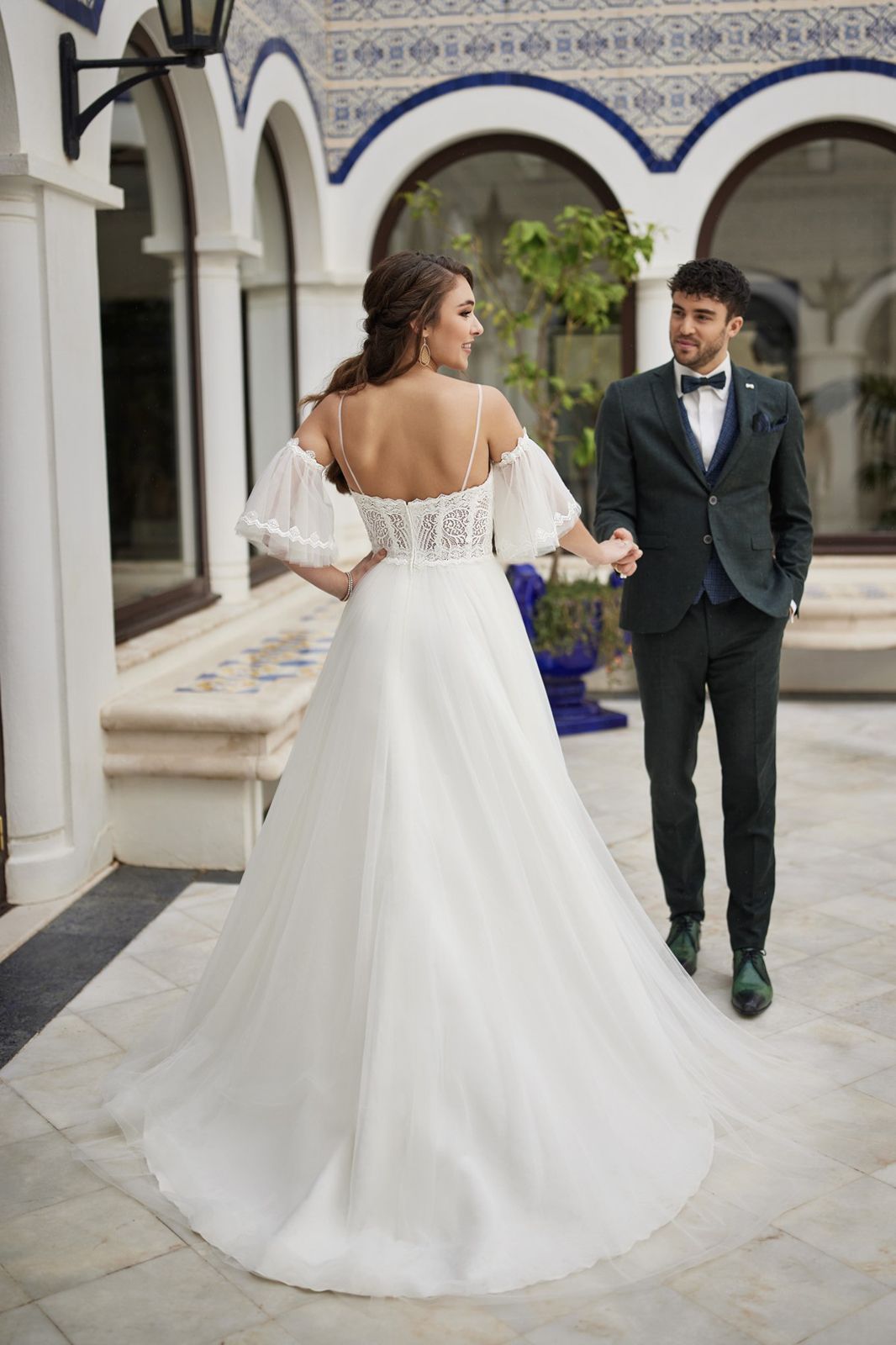 Eine Frau in einem Brautkleid steht vor einem Gebäude.