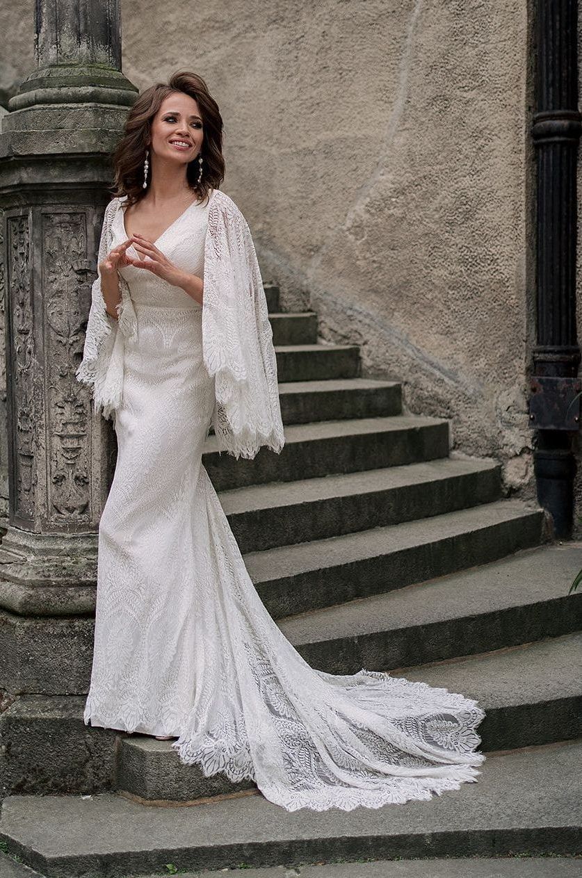 Eine Frau in einem Brautkleid steht in der Wüste.