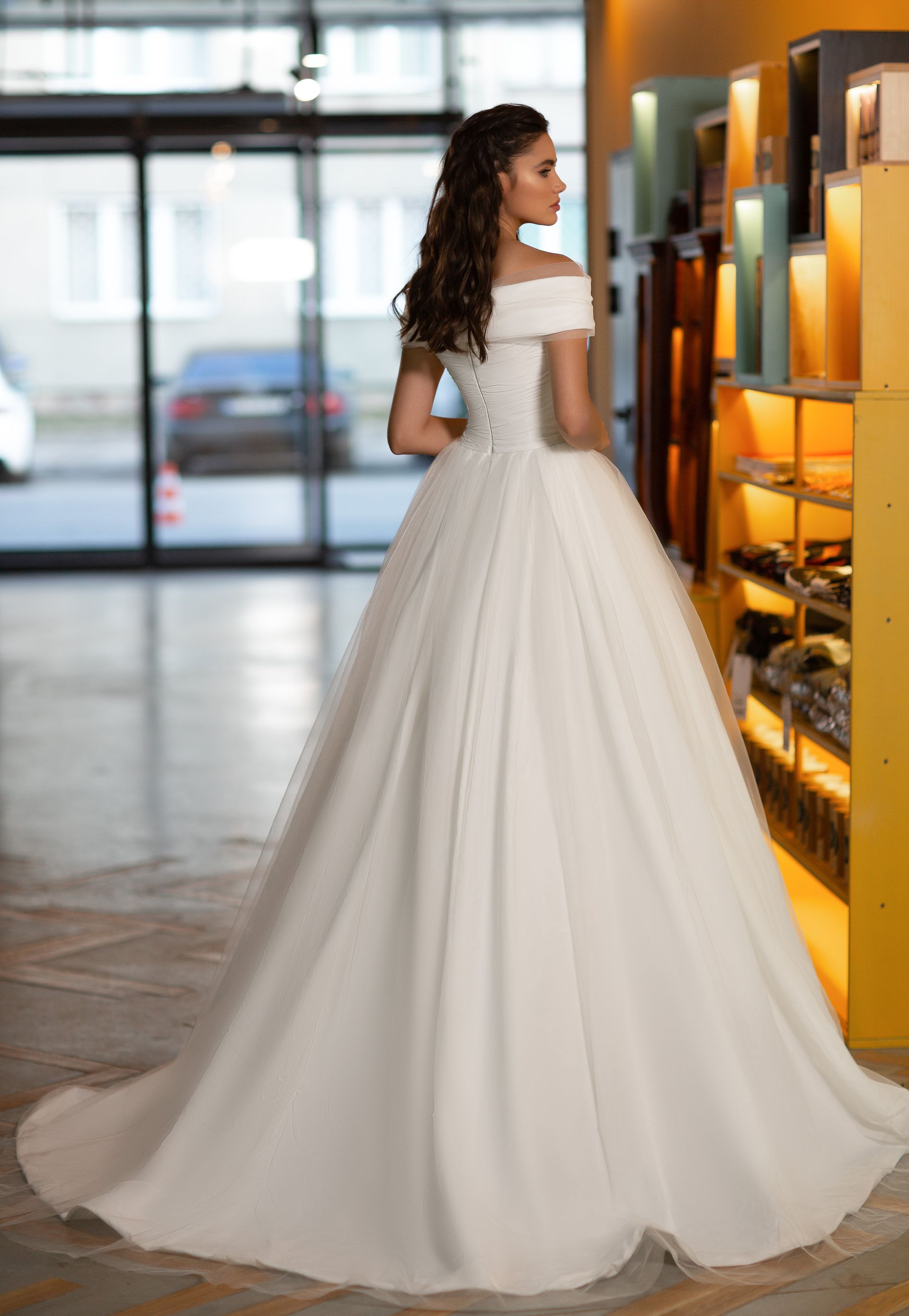 Eine Frau in einem Brautkleid steht auf einer Treppe vor einem Gebäude.