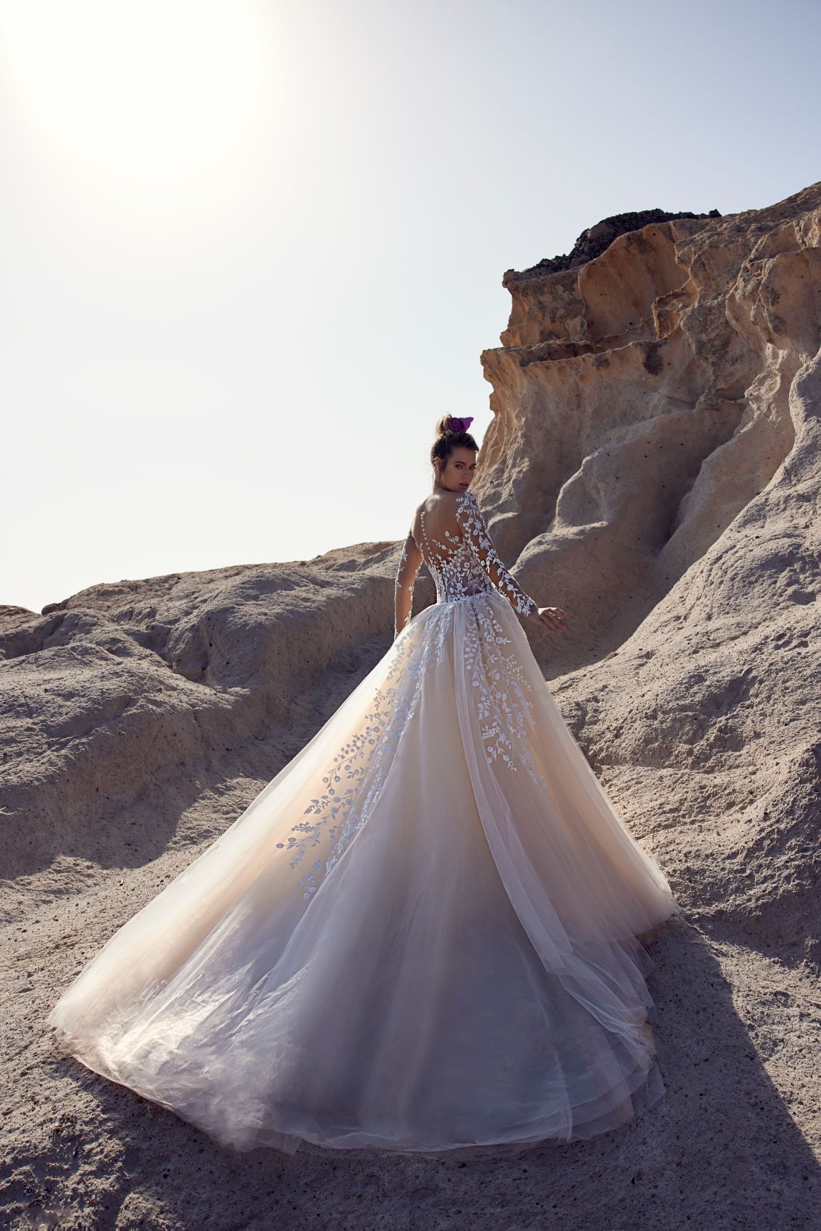 Eine Frau in einem Brautkleid steht in der Wüste.