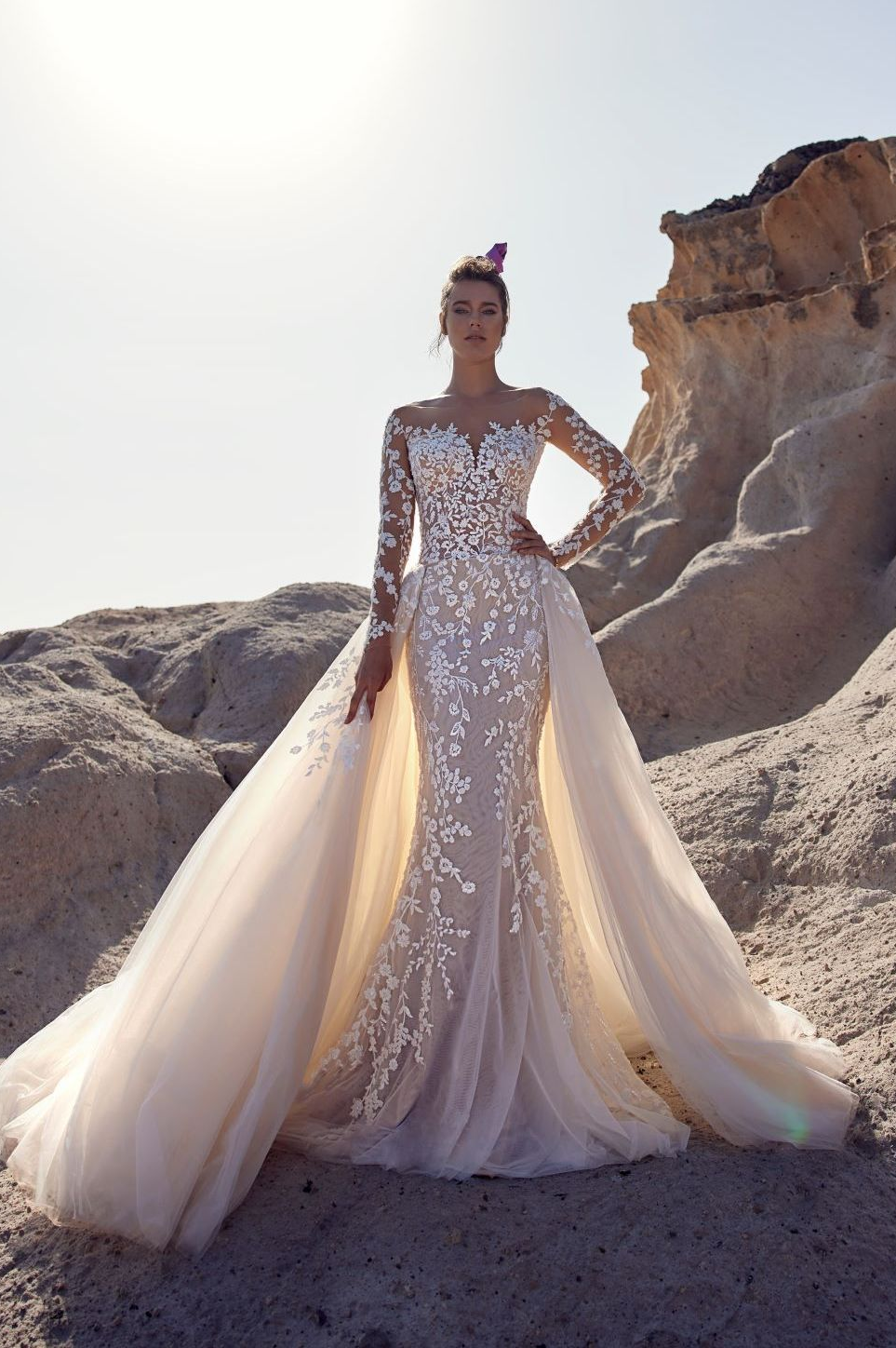 Eine Frau in einem Brautkleid steht in der Wüste.