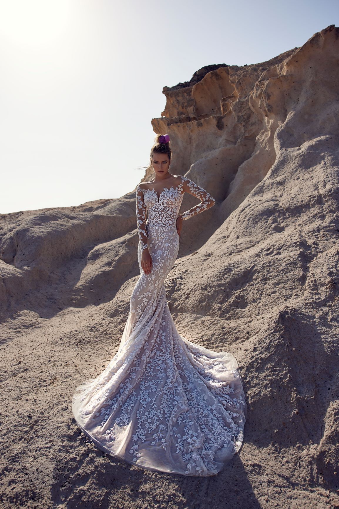 Eine Frau in einem Brautkleid steht in der Wüste.