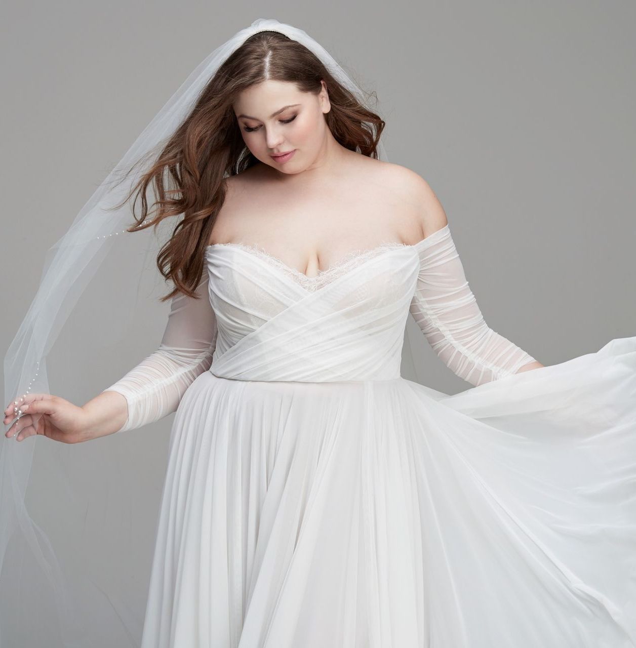 Eine Frau in einem Brautkleid steht auf einer Treppe vor einem Gebäude.