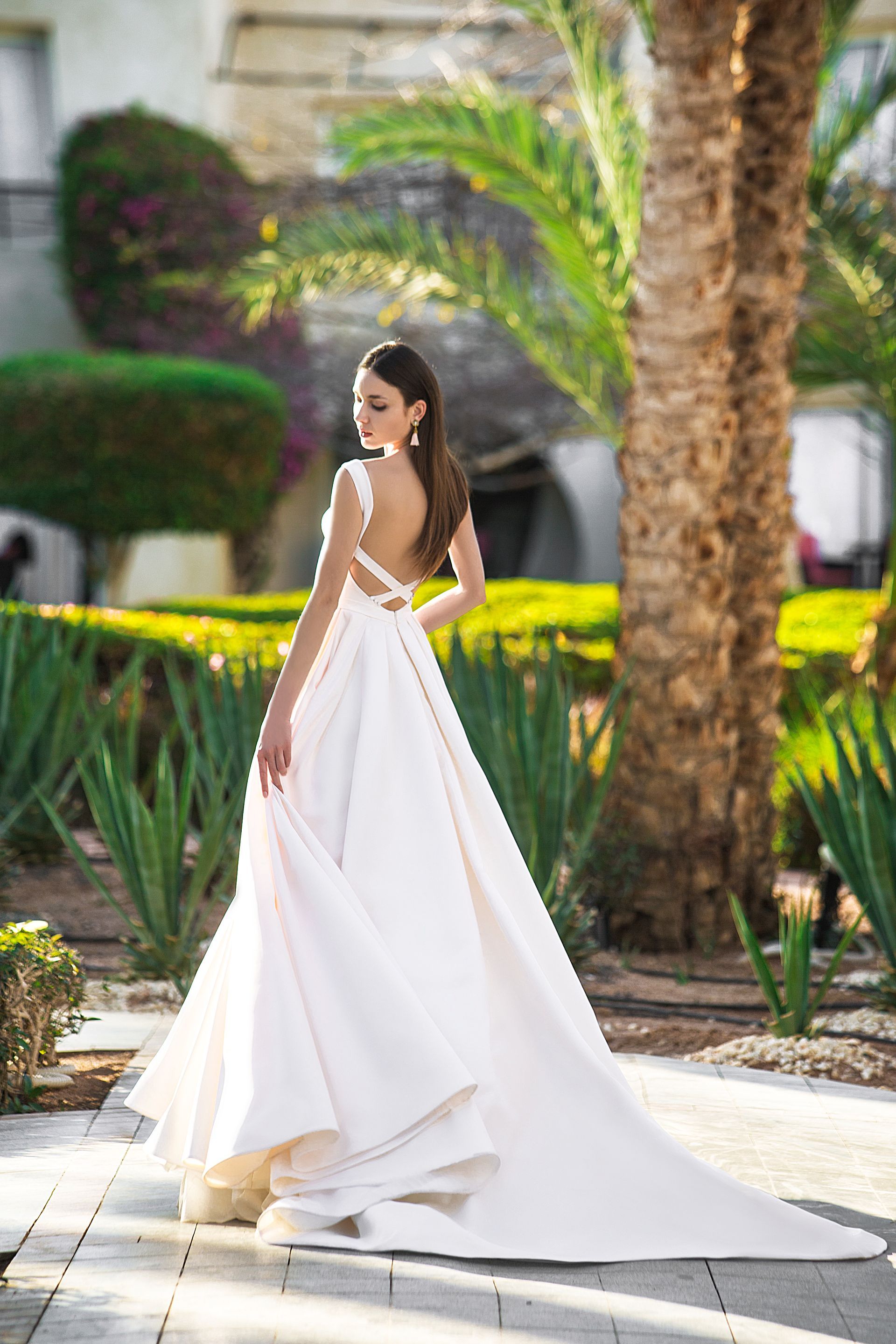 Eine Frau in einem Brautkleid steht auf einer Treppe vor einem Gebäude.