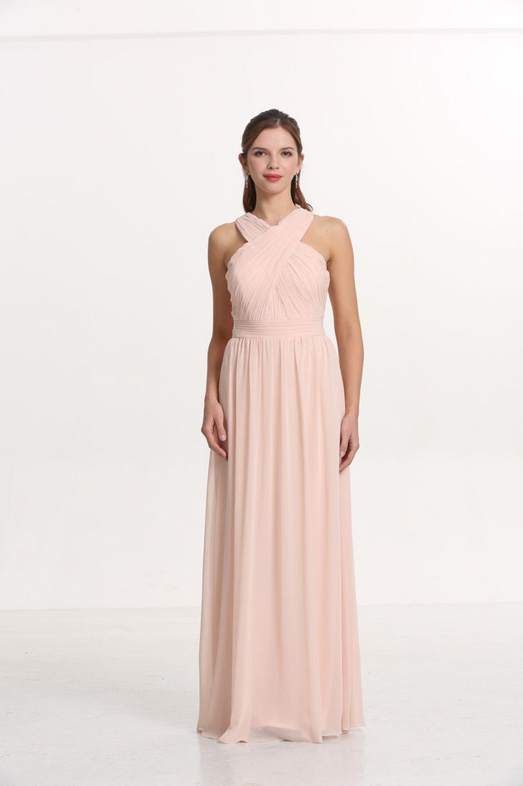 Eine Frau in einem grünen schulterfreien Kleid steht auf einem Holzboden.