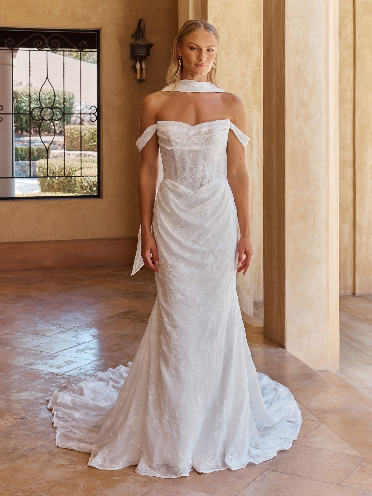 Eine Frau in einem Brautkleid steht in der Wüste.