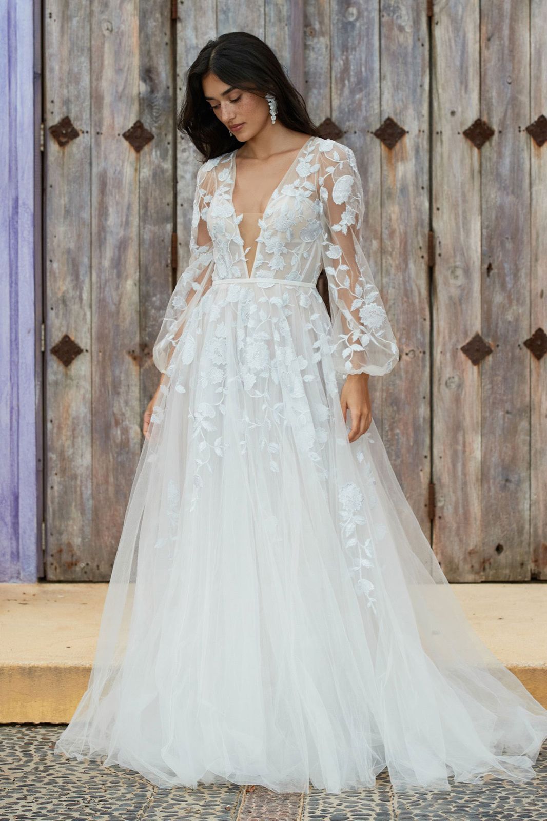 Eine Frau in einem Brautkleid steht in der Wüste.