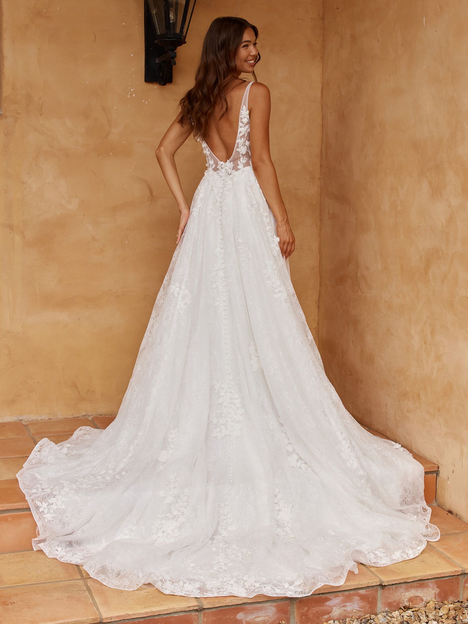 Eine Frau in einem Brautkleid steht in der Wüste.