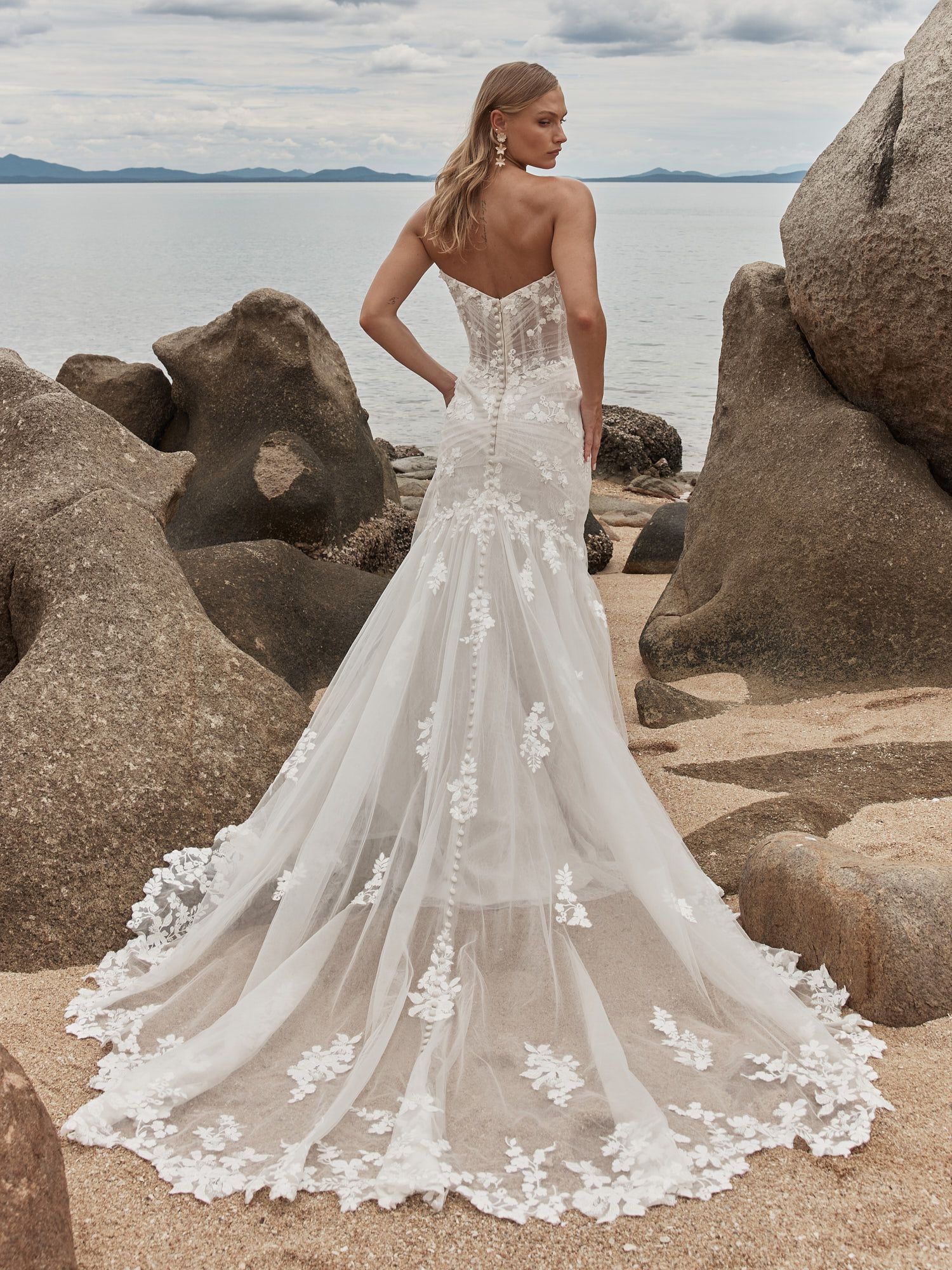Eine Frau in einem Brautkleid steht in der Wüste.