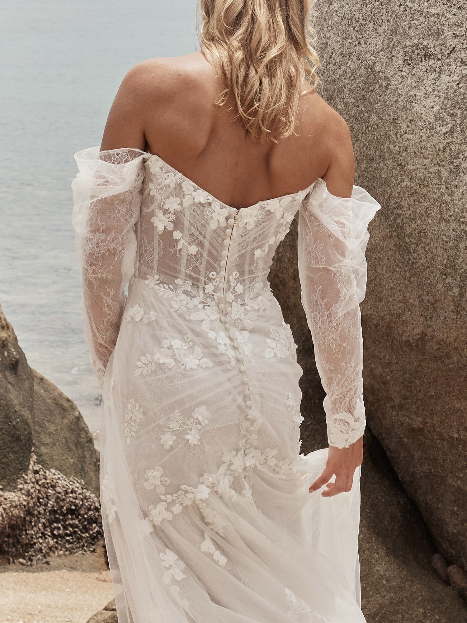 Eine Frau in einem Brautkleid steht in der Wüste.