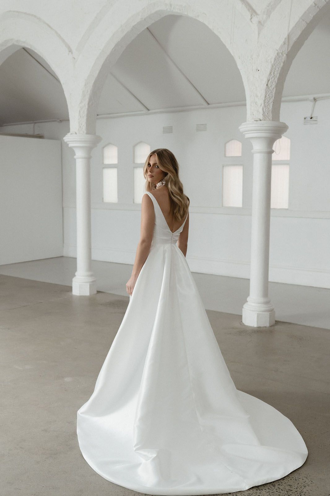 Eine Frau in einem Brautkleid steht in der Wüste.
