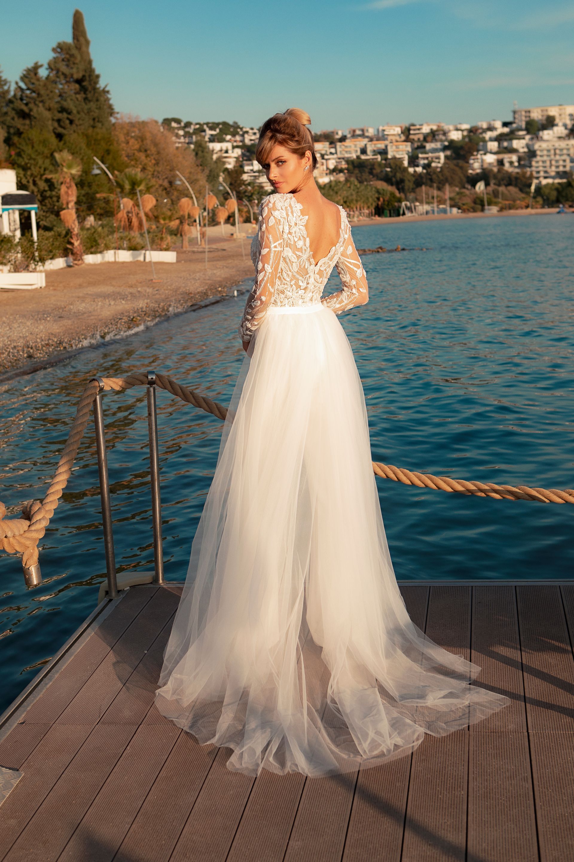 Eine Frau in einem Brautkleid steht auf einer Treppe vor einem Gebäude.