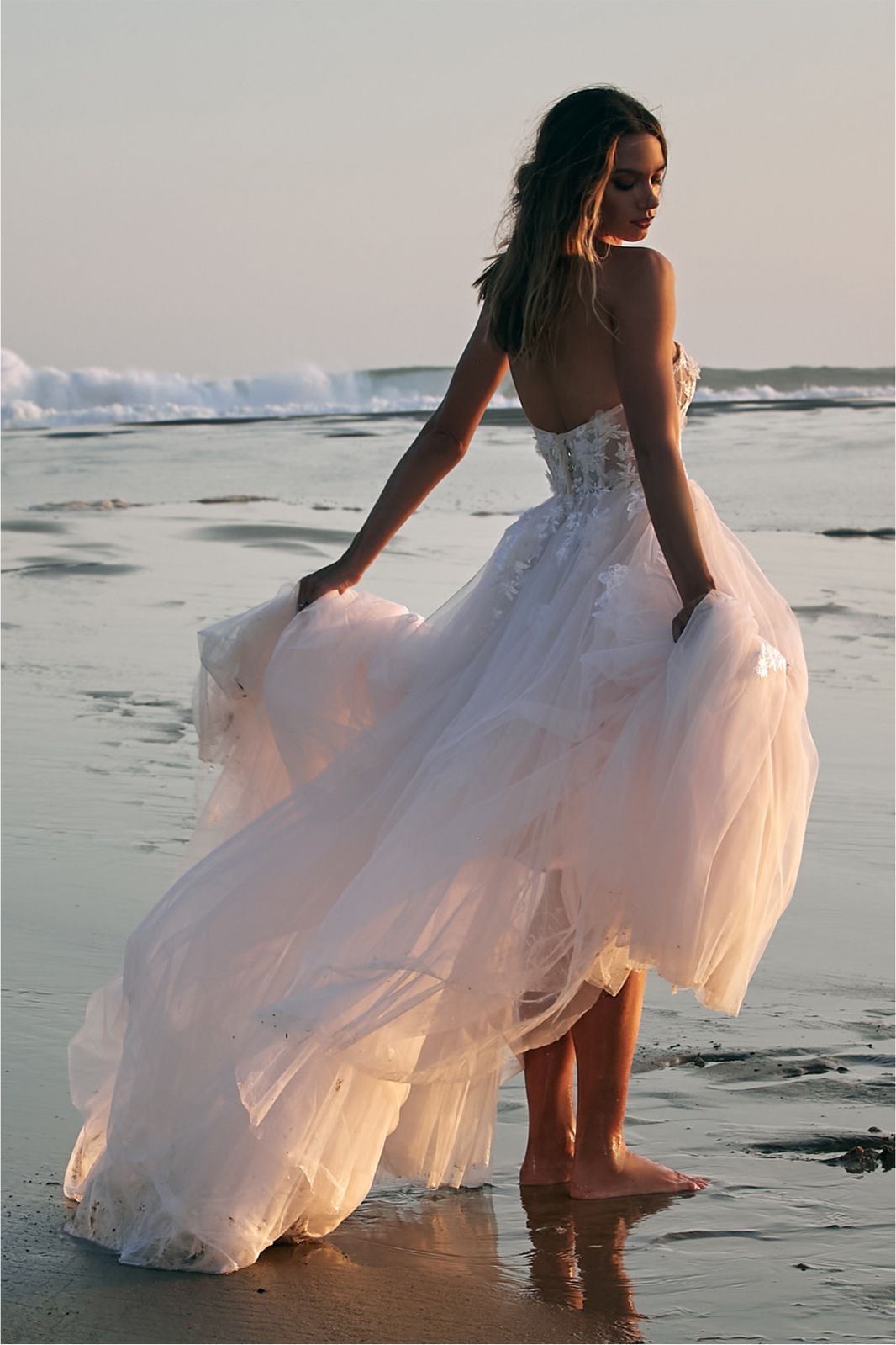 Eine Frau in einem Brautkleid steht auf einer Treppe vor einem Gebäude.