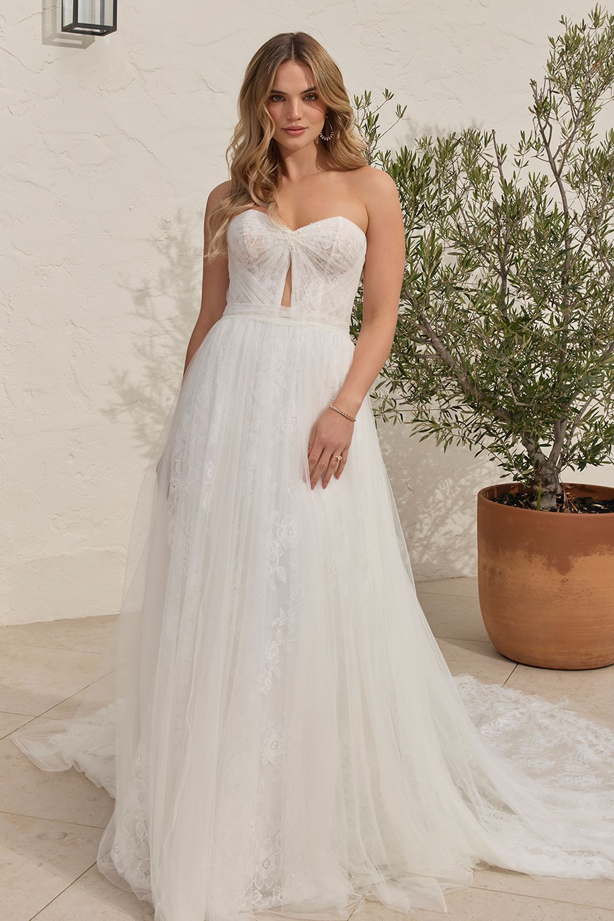Eine Frau in einem Brautkleid steht in der Wüste.