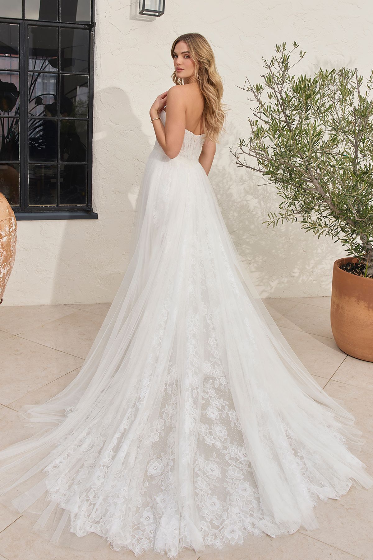 Eine Frau in einem Brautkleid steht in der Wüste.