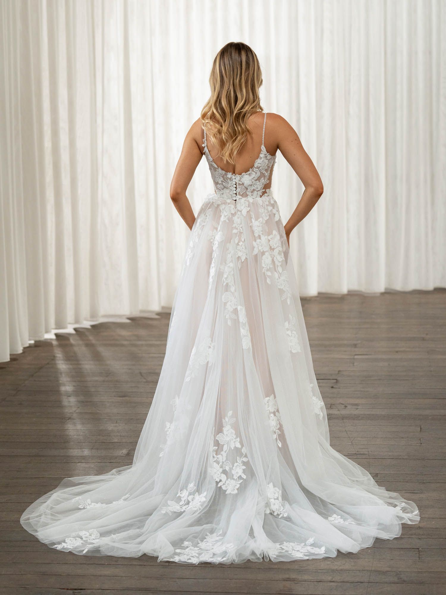 Eine Frau in einem Brautkleid steht in der Wüste.