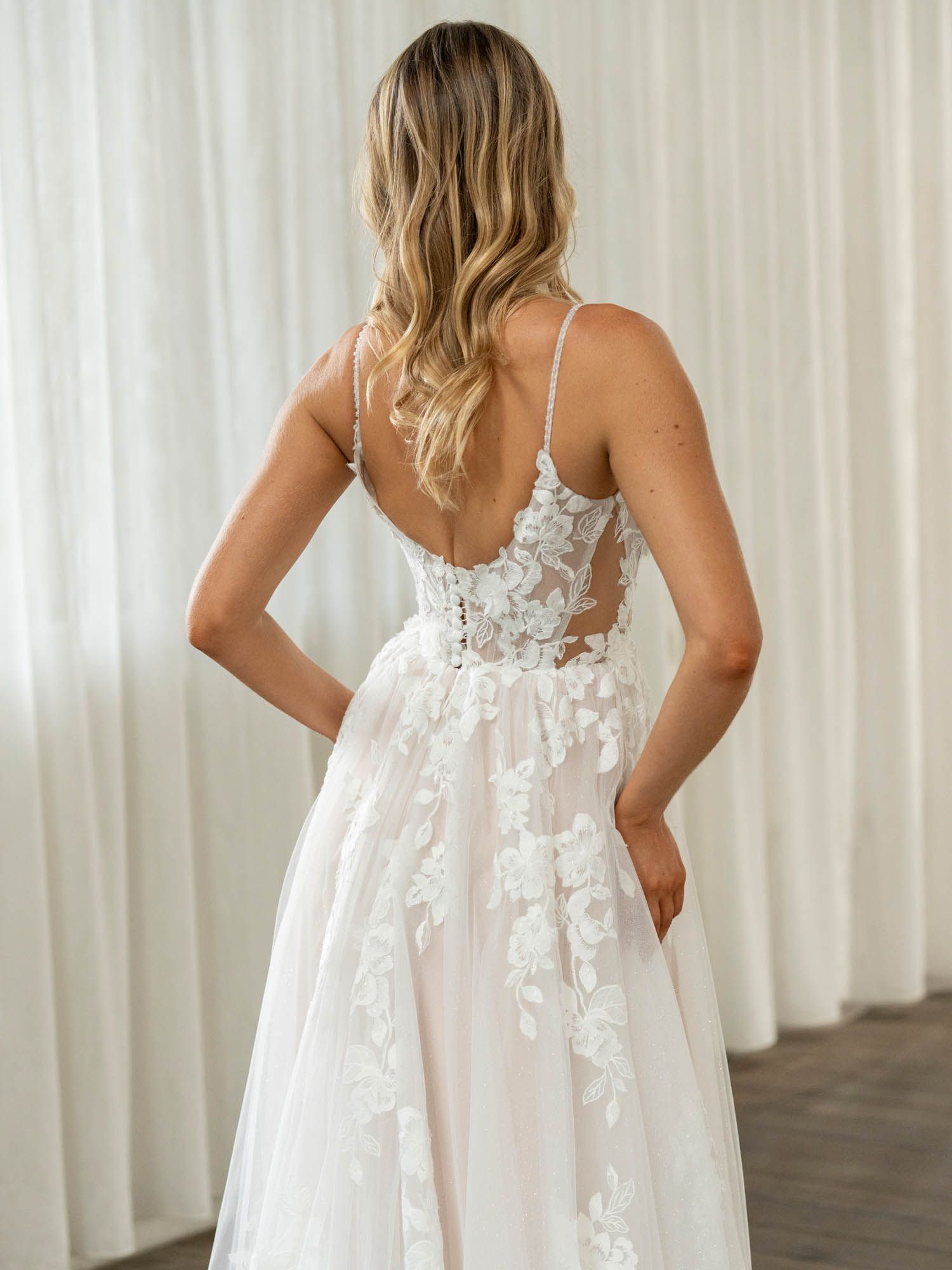 Eine Frau in einem Brautkleid steht in der Wüste.