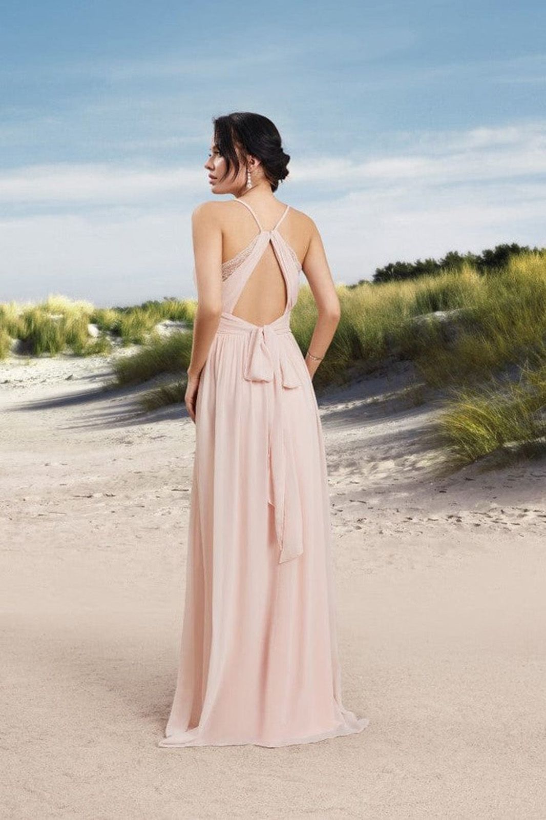 Eine Frau in einem roten Satinkleid steht auf einem Holzboden.