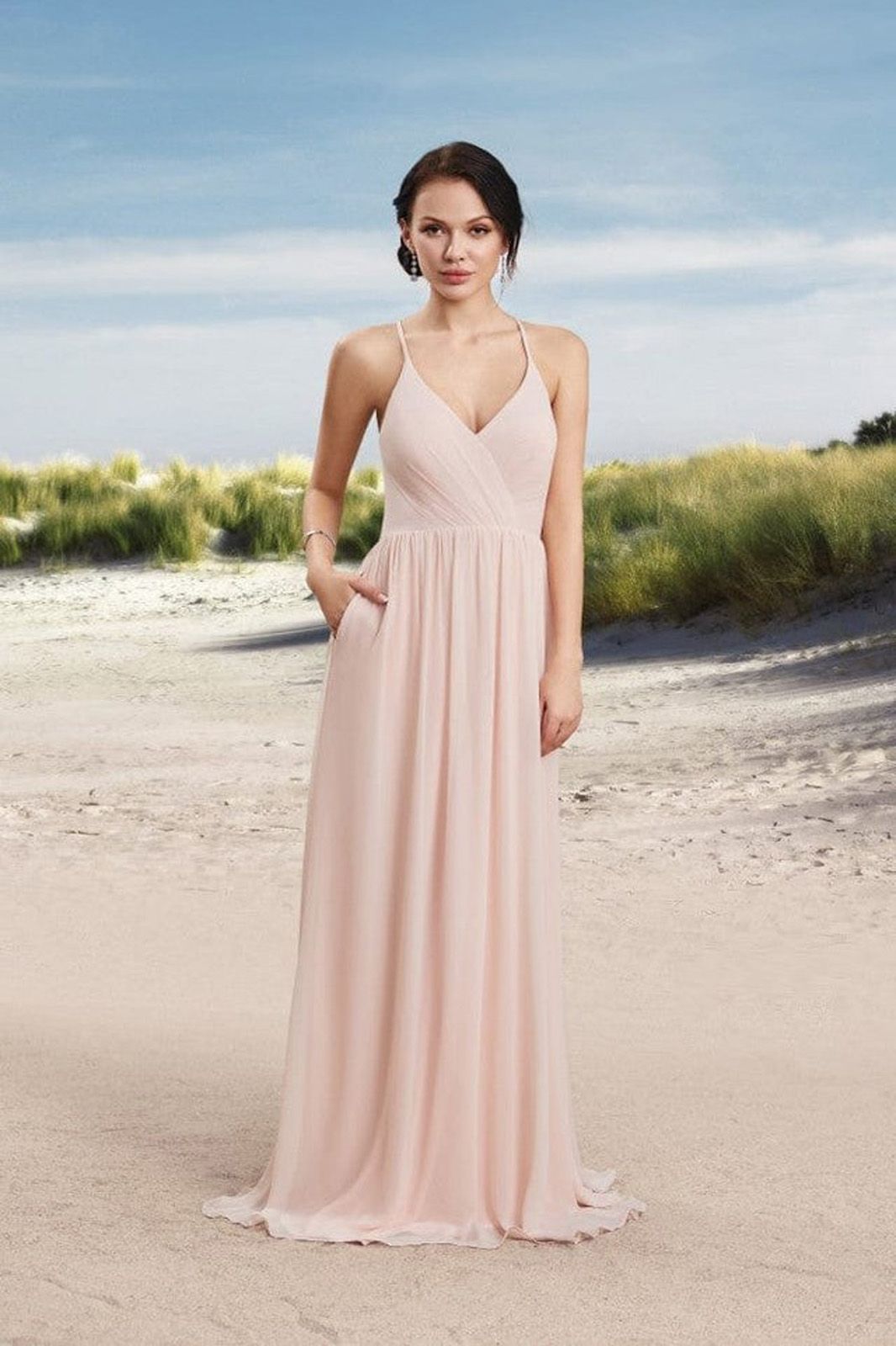 Eine Frau in einem langen roten Kleid steht auf einem Holzboden.