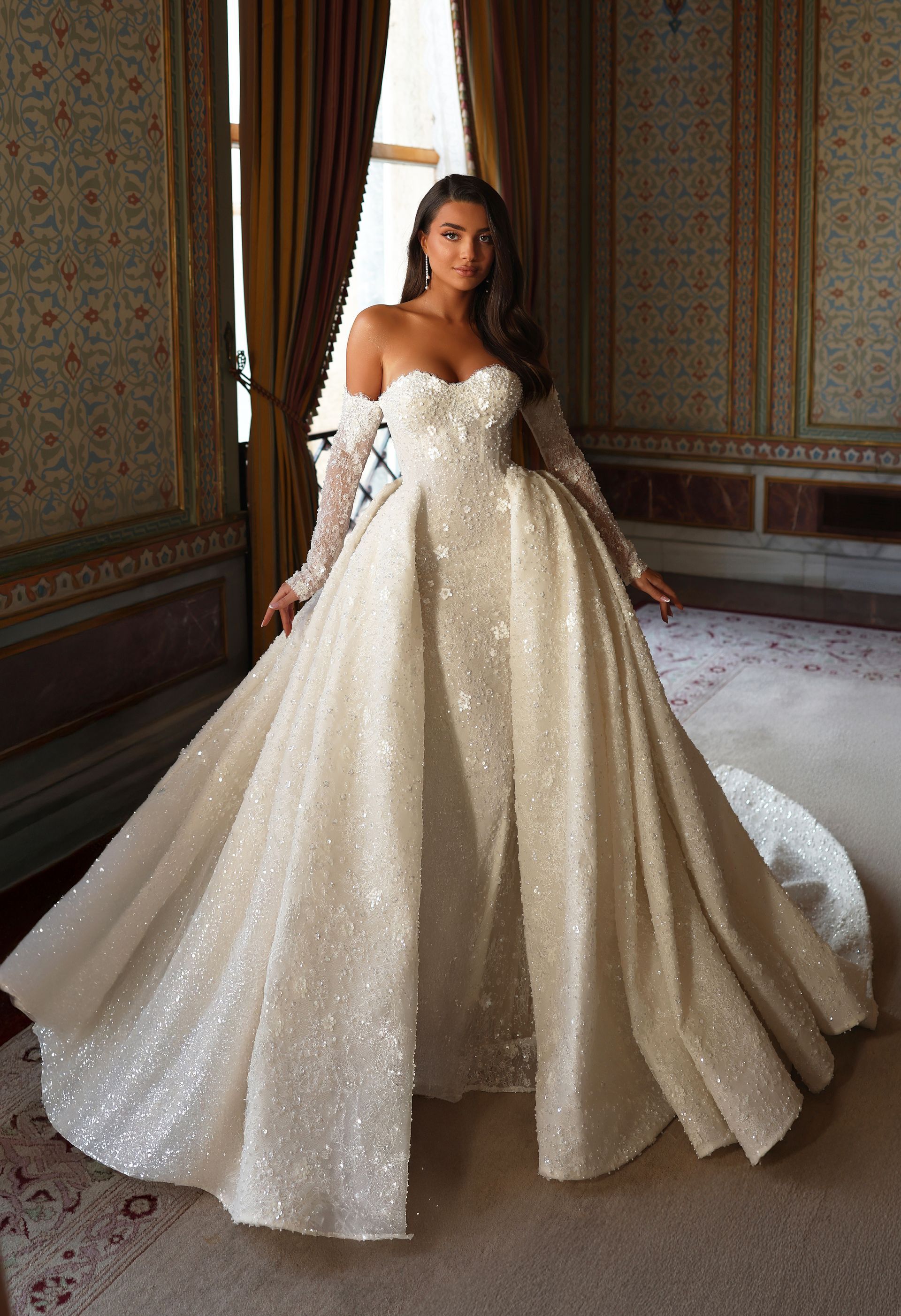 Eine Frau in einem weißen Brautkleid steht in einem Raum.