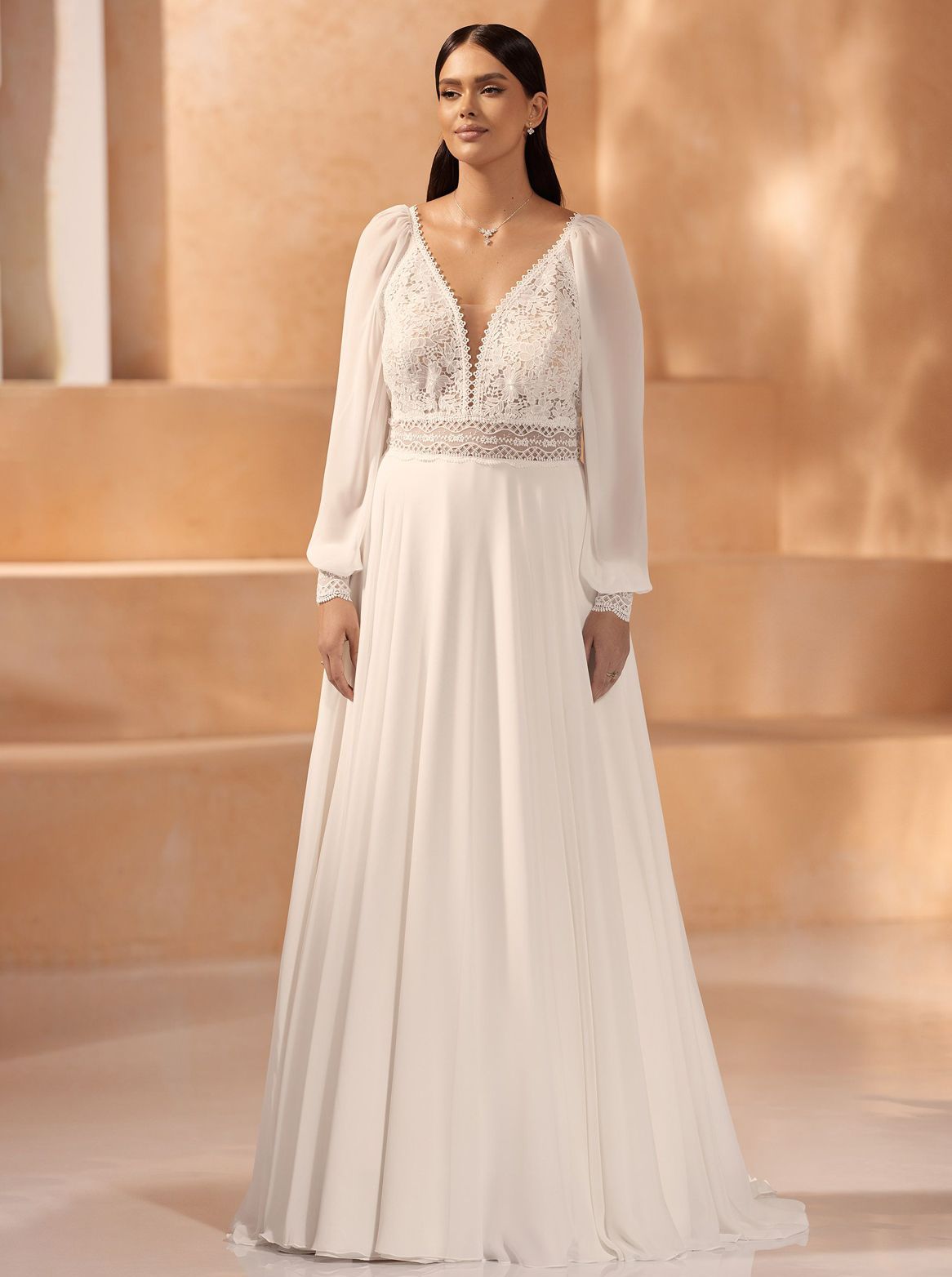 Eine Frau in einem weißen Brautkleid steht vor einem Gebäude.