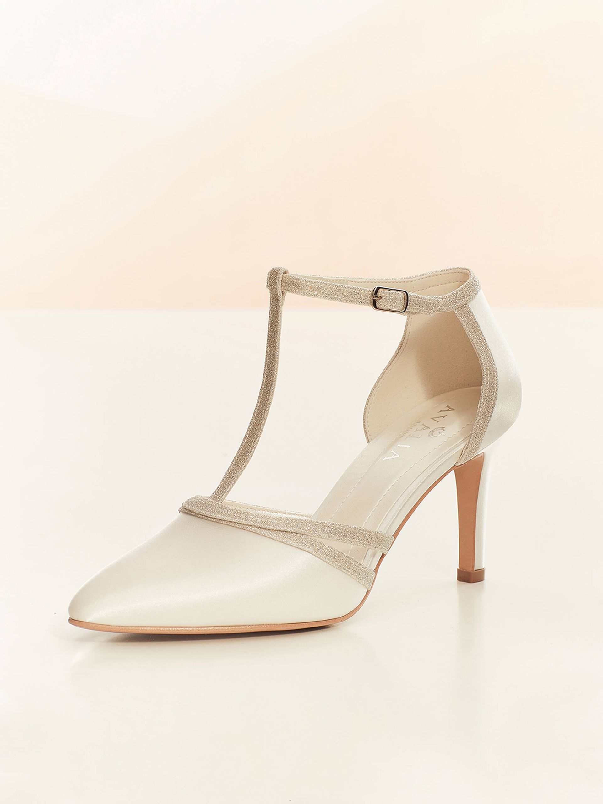 Ein Paar weiße Brautschuhe mit Riemchen auf weißem Untergrund.