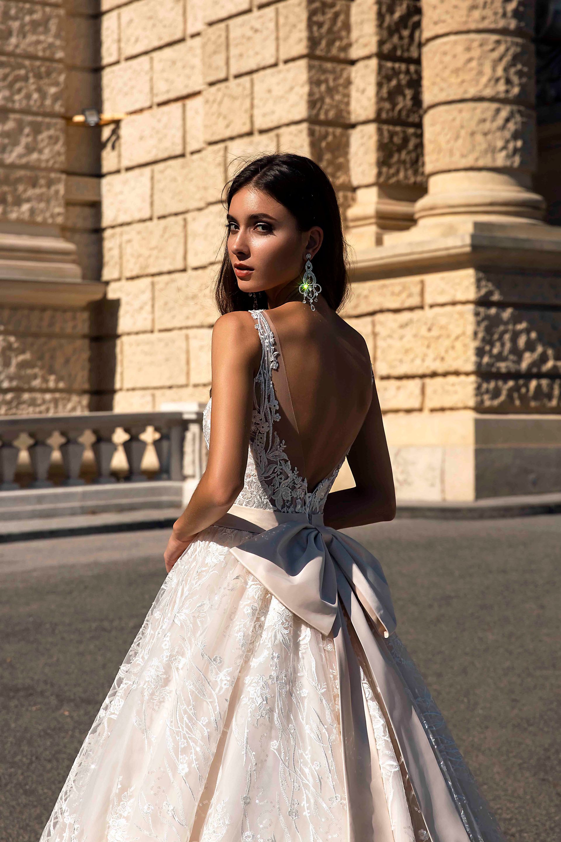 Eine Frau in einem Brautkleid steht vor einem Gebäude.