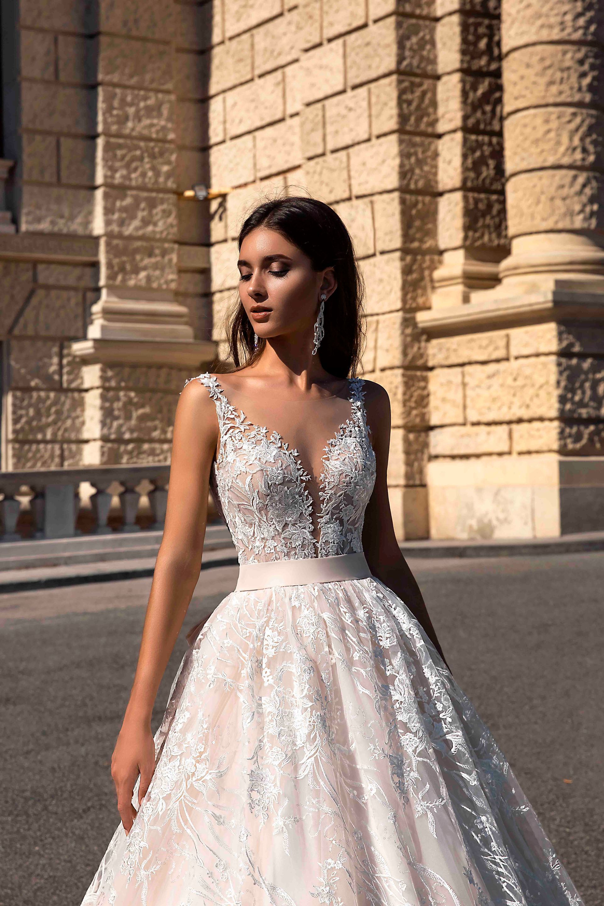 Eine Frau in einem Brautkleid steht vor einem Gebäude.