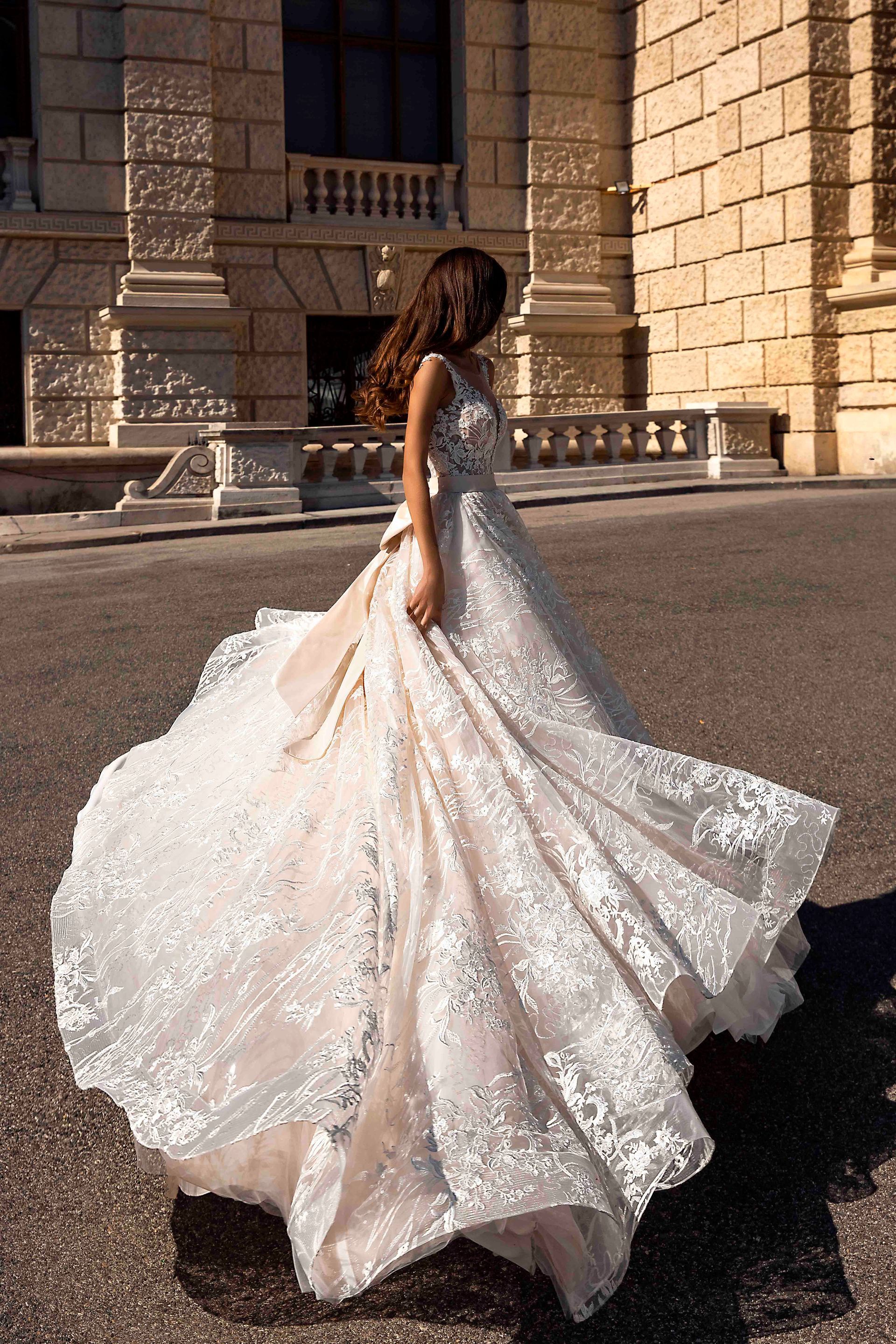 Eine Frau in einem Brautkleid geht die Straße entlang.