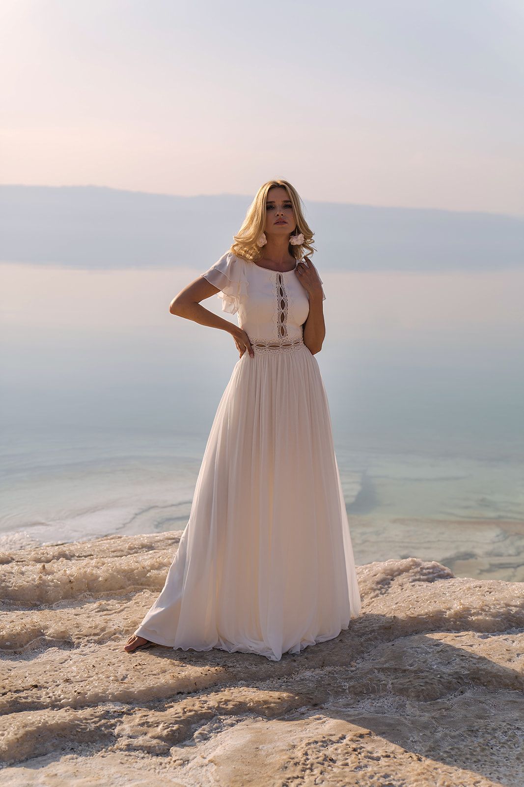 Eine Frau in einem Brautkleid steht vor einem Gebäude.