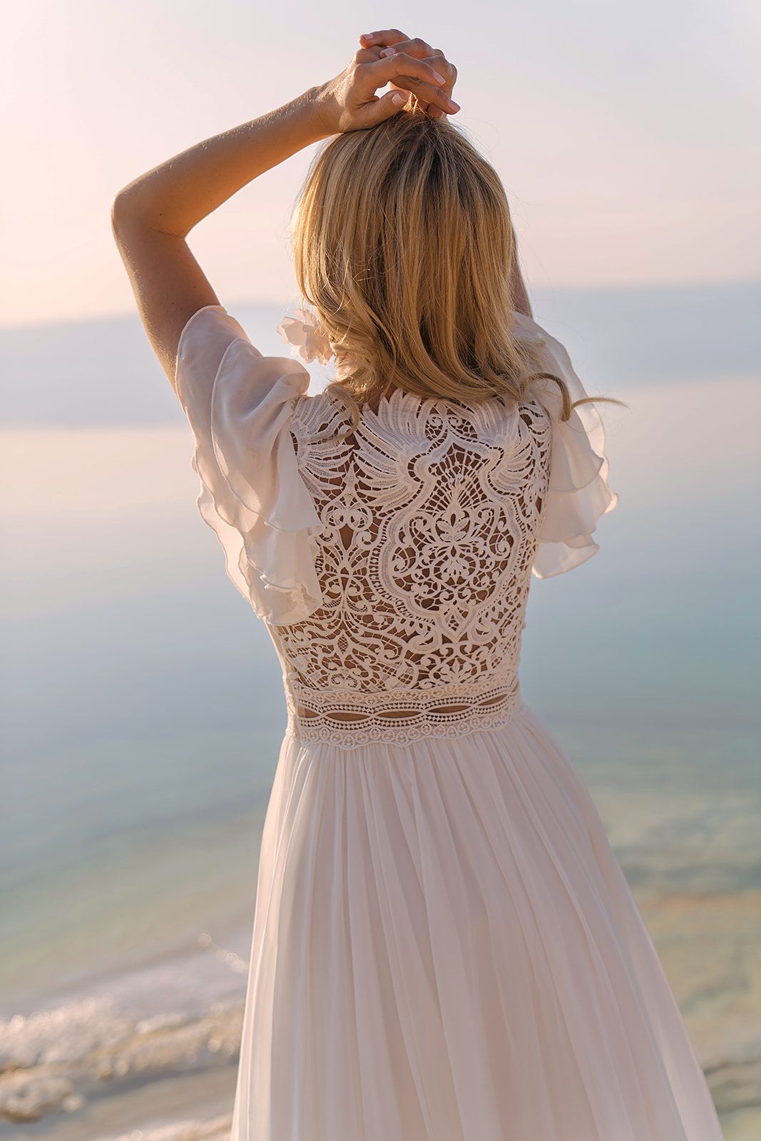 Eine Frau in einem Brautkleid steht vor einem Gebäude.