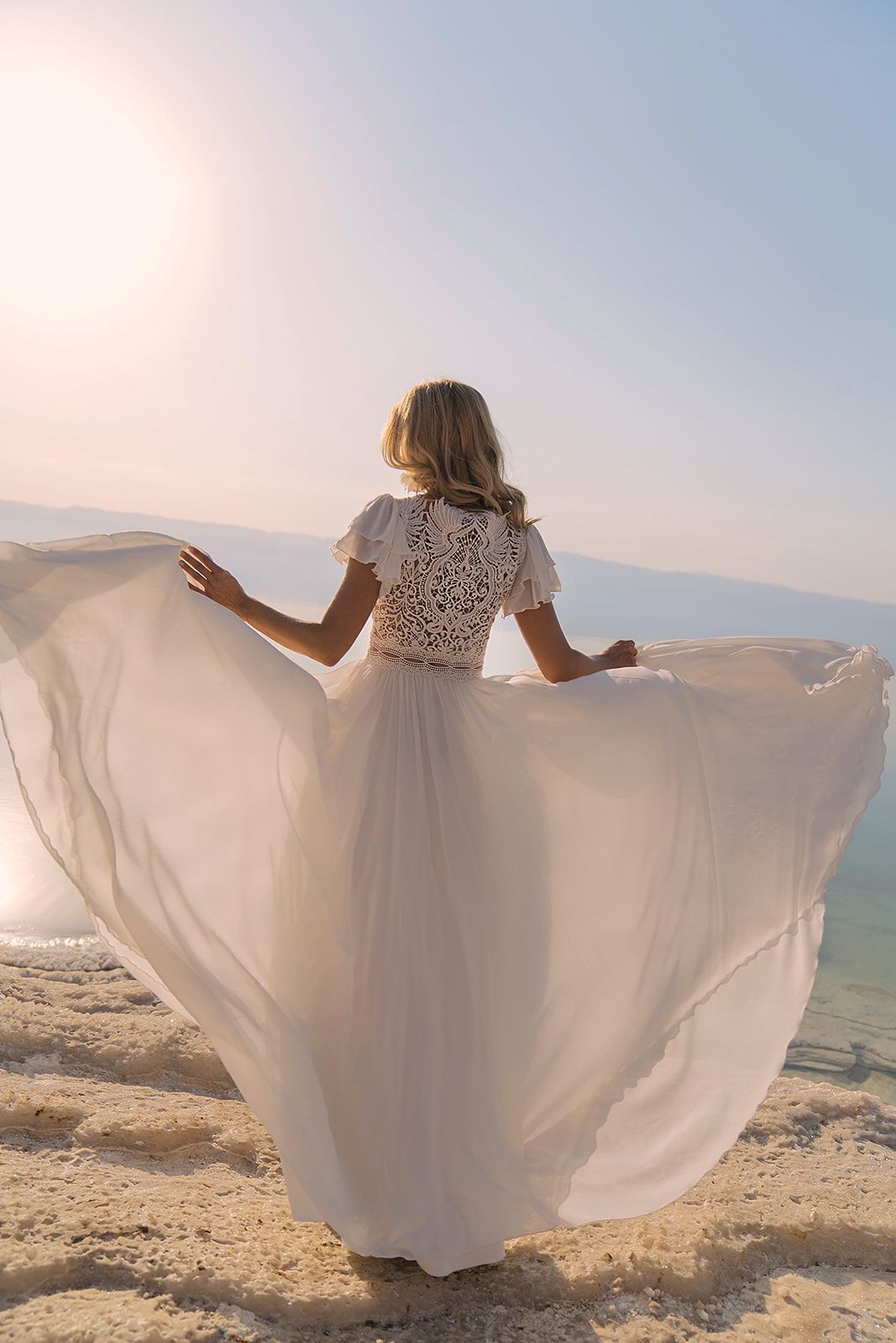 Eine Frau in einem Brautkleid steht vor einem Gebäude.