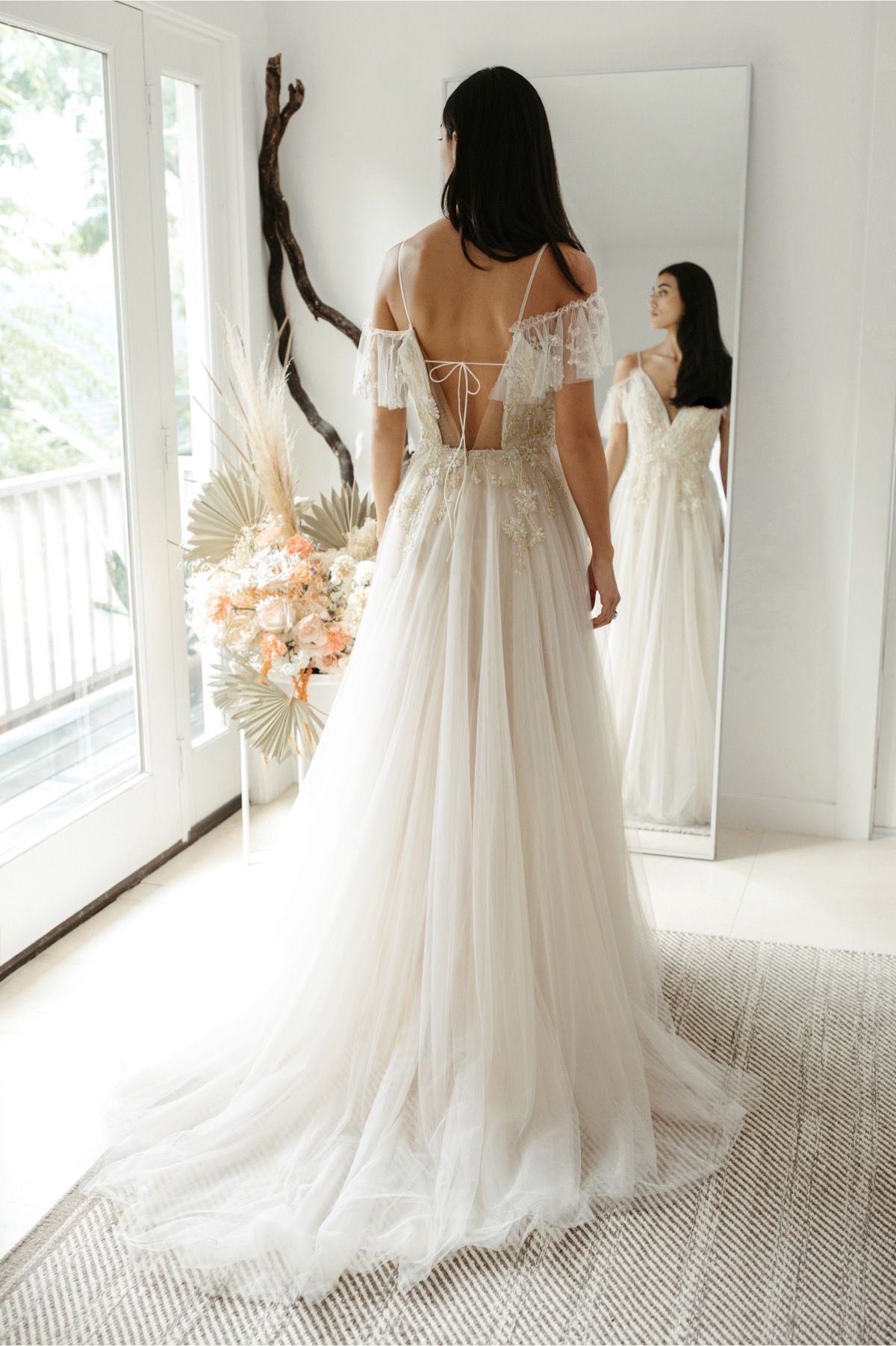 Eine Frau in einem Brautkleid steht in der Wüste.