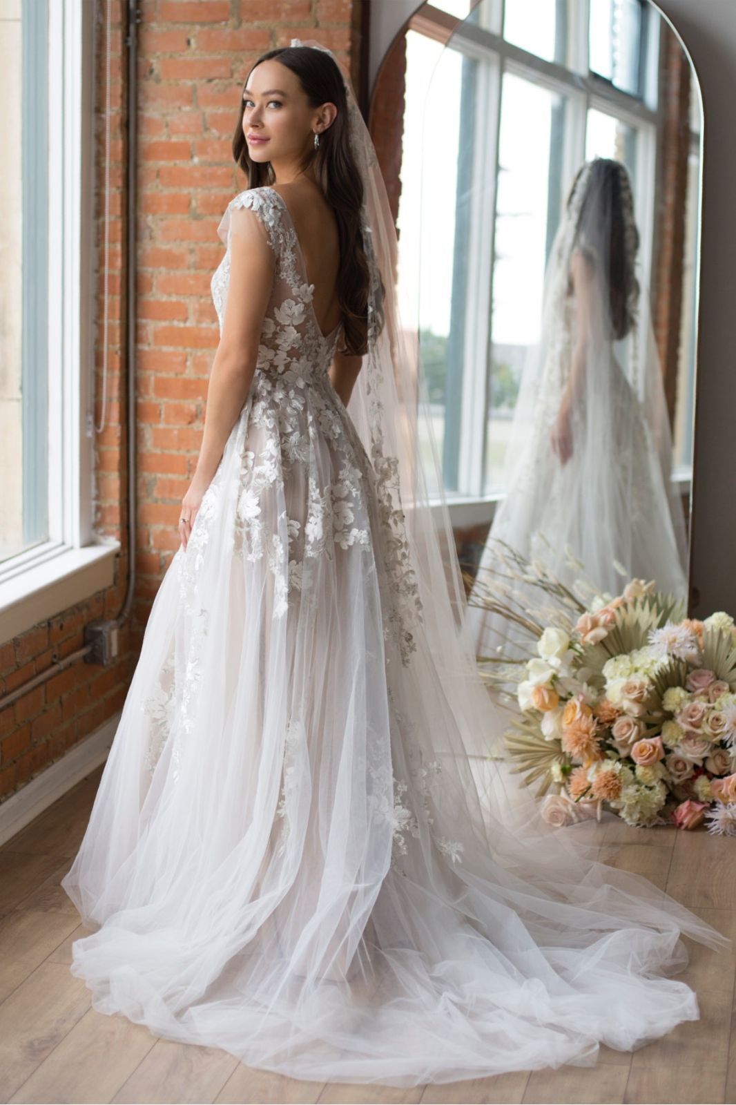 Eine Frau in einem Brautkleid steht auf einer Treppe vor einem Gebäude.