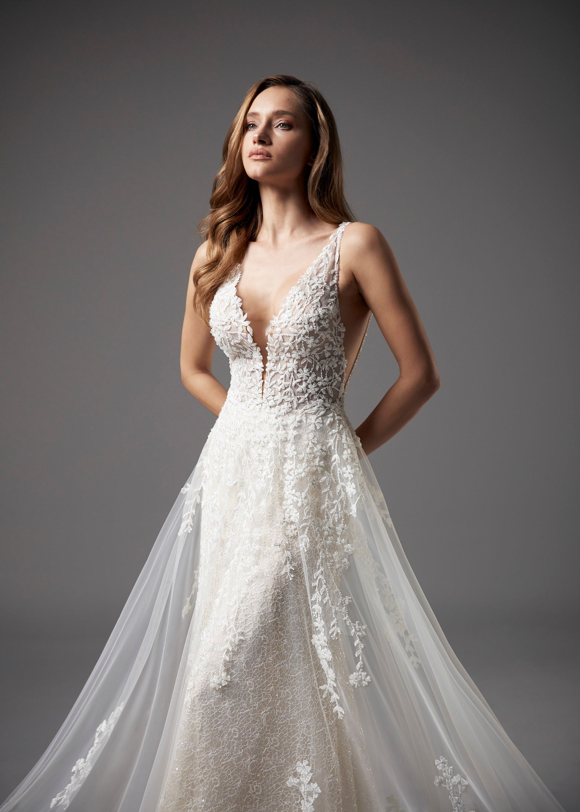 Eine Frau trägt ein weißes Brautkleid mit tiefem Ausschnitt.