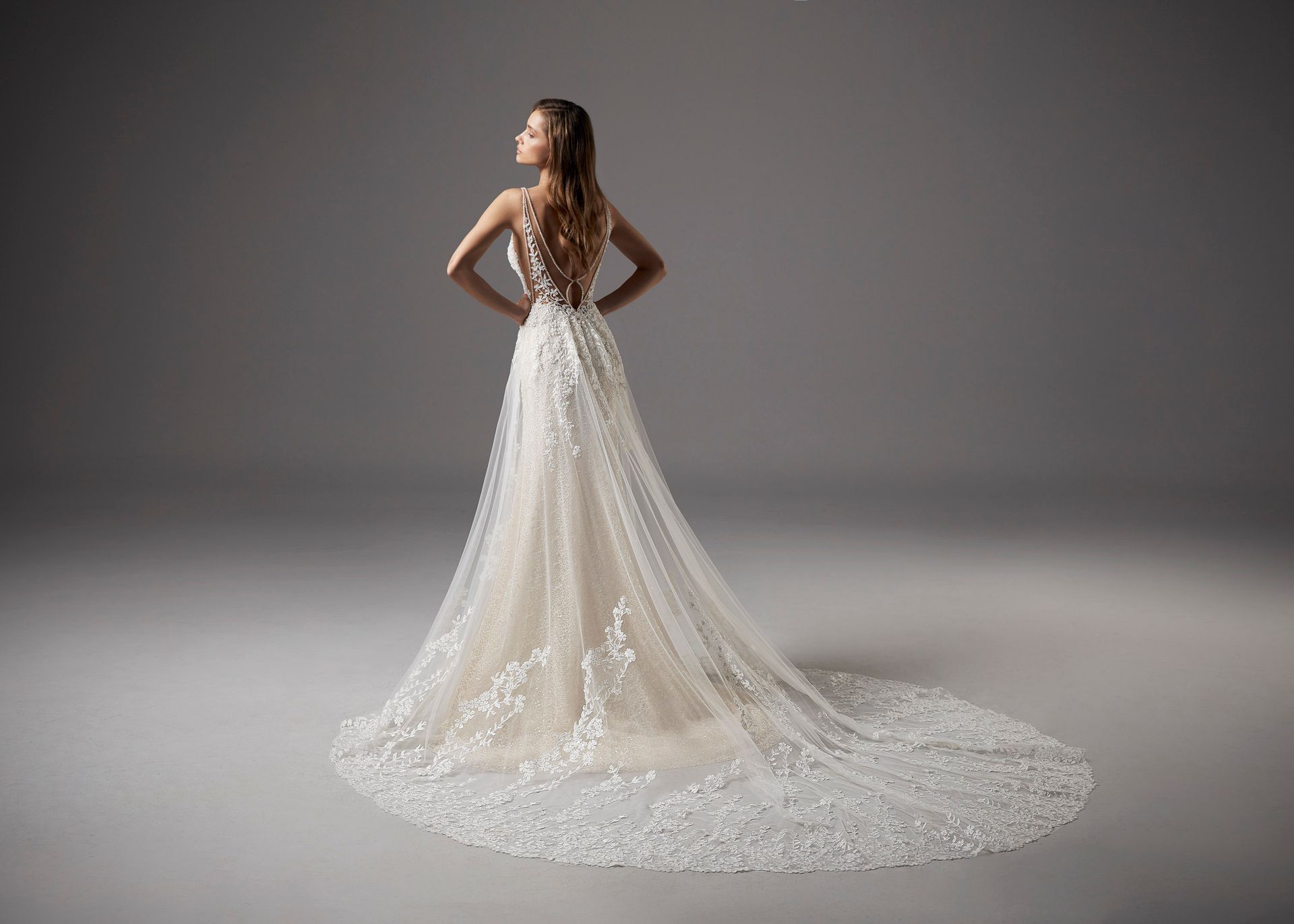 Der Rücken einer Frau in einem Brautkleid mit langer Schleppe.